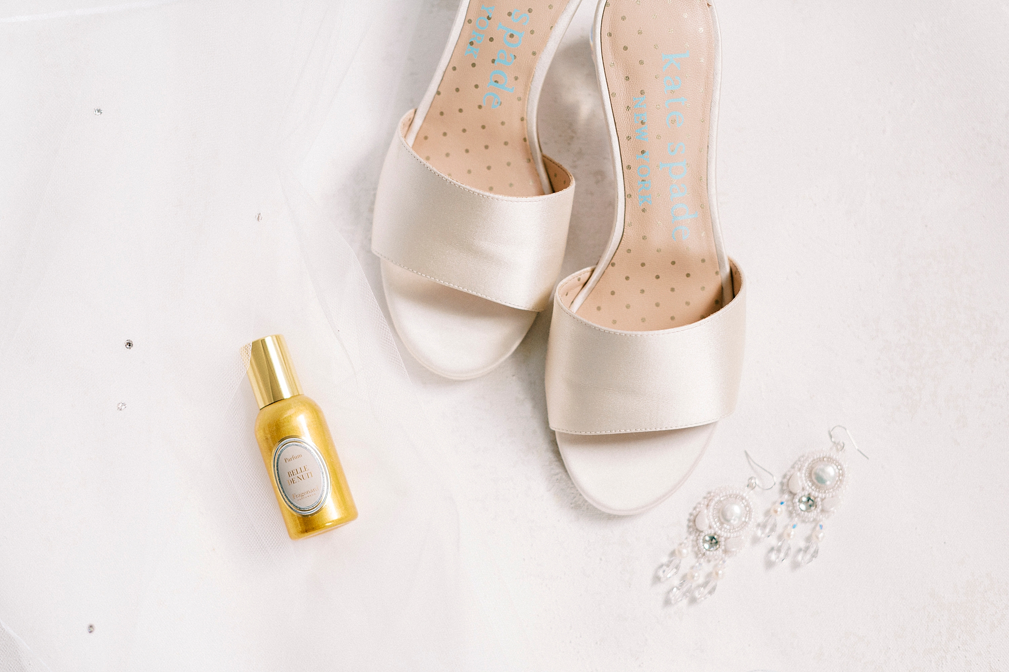 bride's ivory shoes and perfume bottle