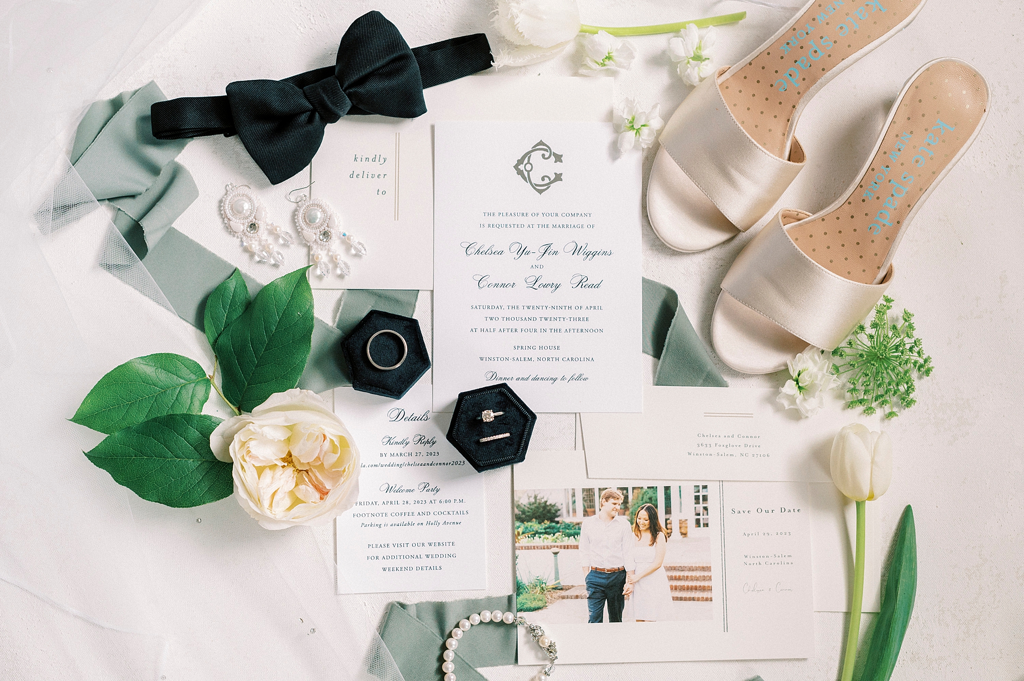 bride's shoes, rings in black ring box, invitation suite and green leaves for spring wedding at The Spring House