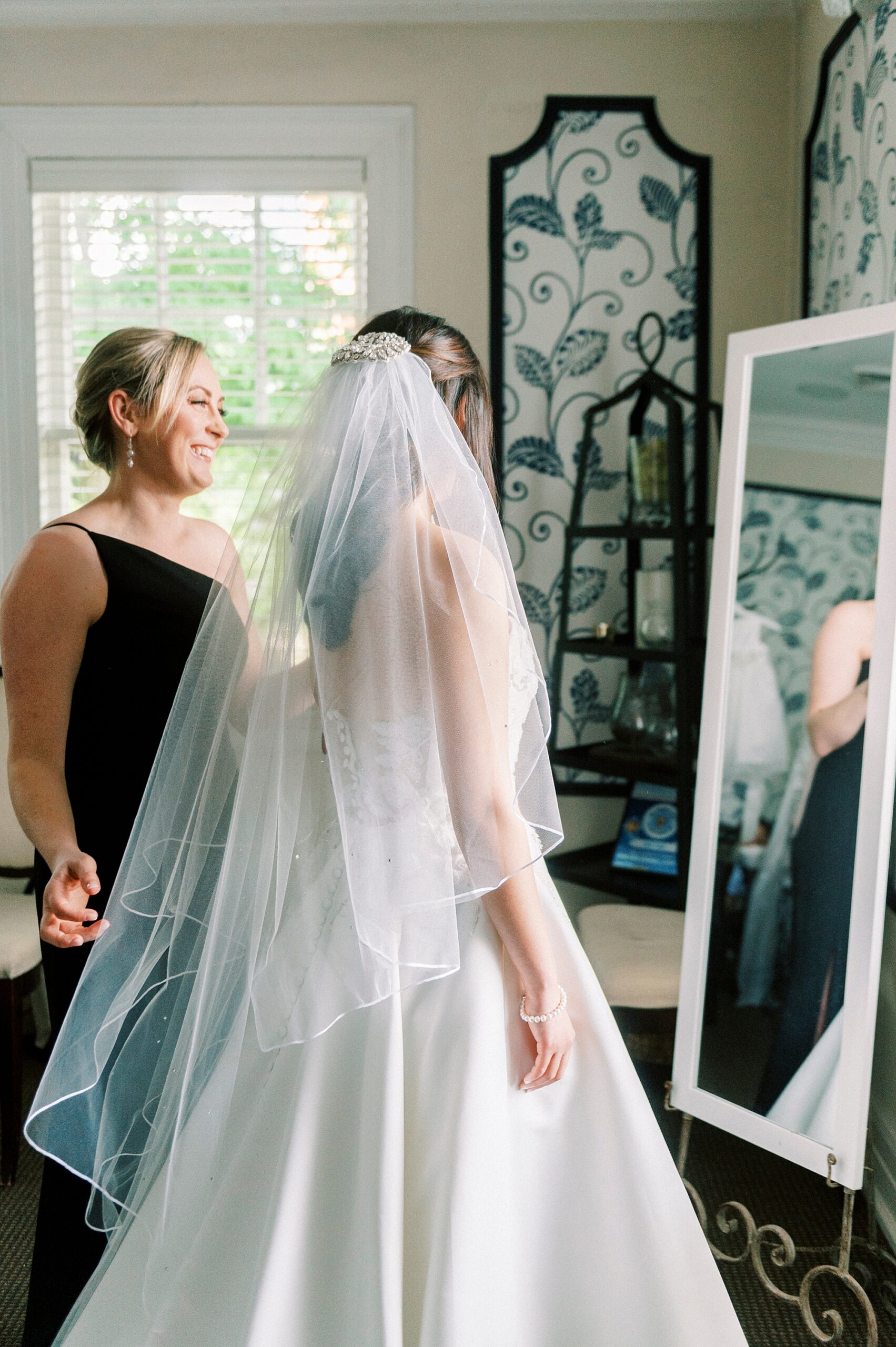 bride looks at self in mirror in bridal suite at The Spring House