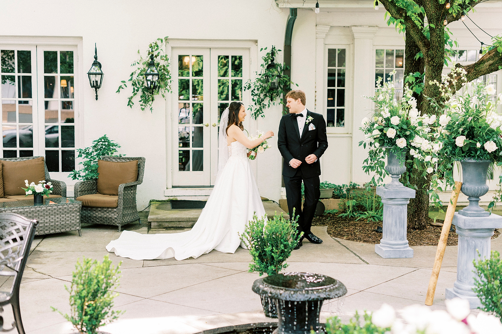 groom turns to look at bride during first look outside The Spring House