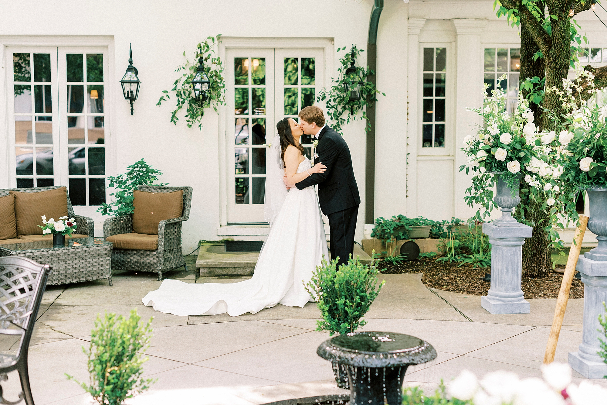 bride and groom kiss outside French doors at The Spring House