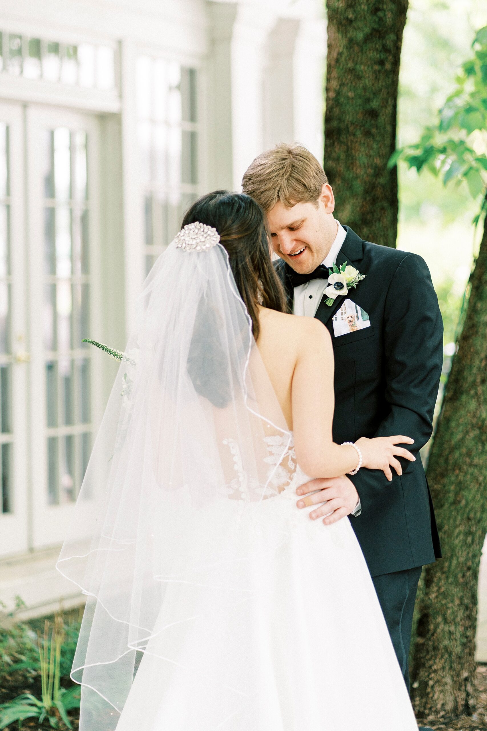 bride and groom lean into each other outside The Spring House