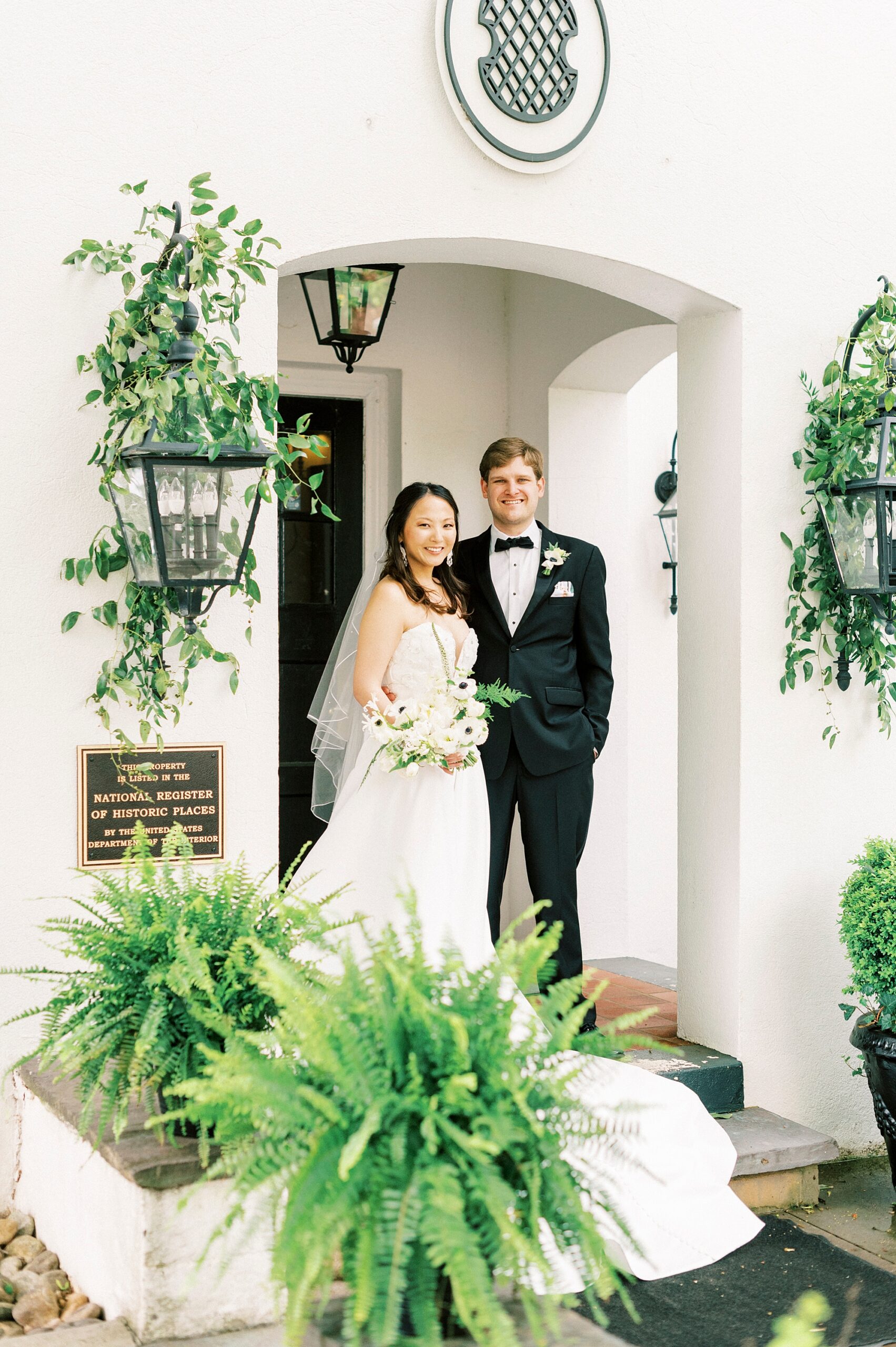 bride and groom stand on front porch of The Spring House