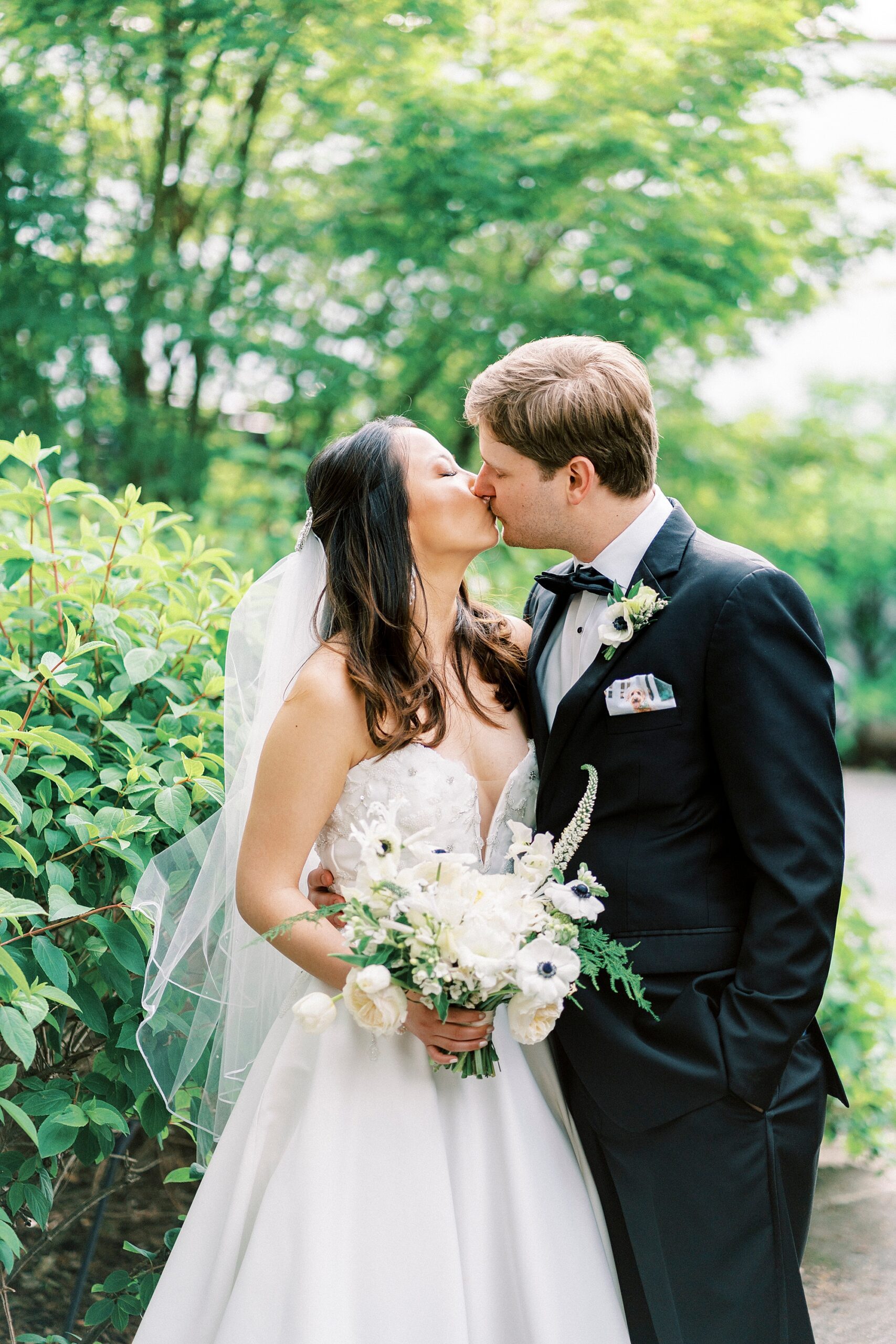 newlyweds kiss each other in garden at The Spring House