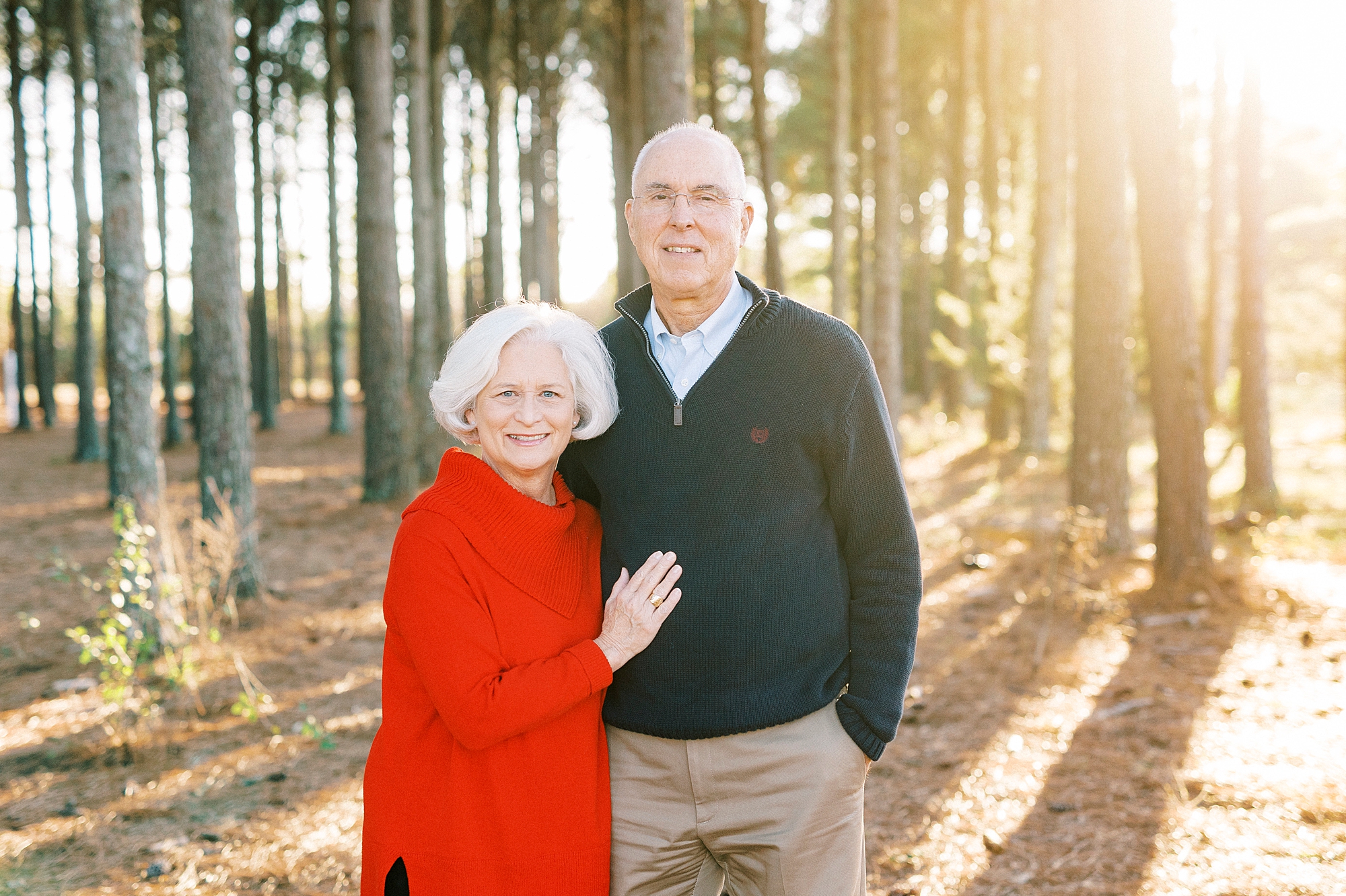 older couple hugs in woods during fall family photos