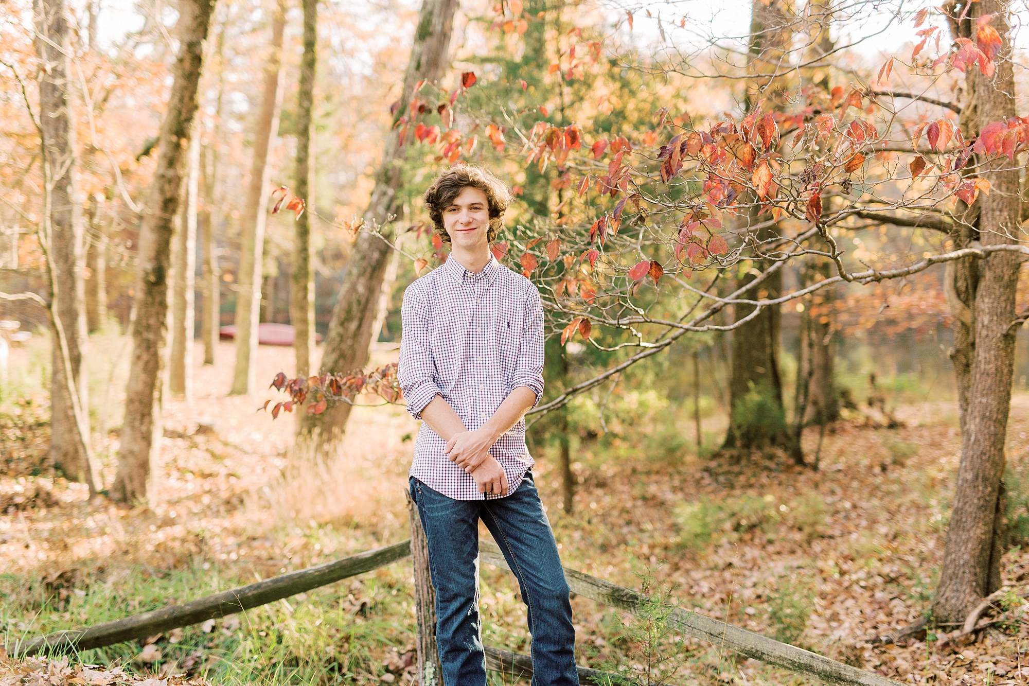 senior stands with hands in front of him during fall photos in Midland NC