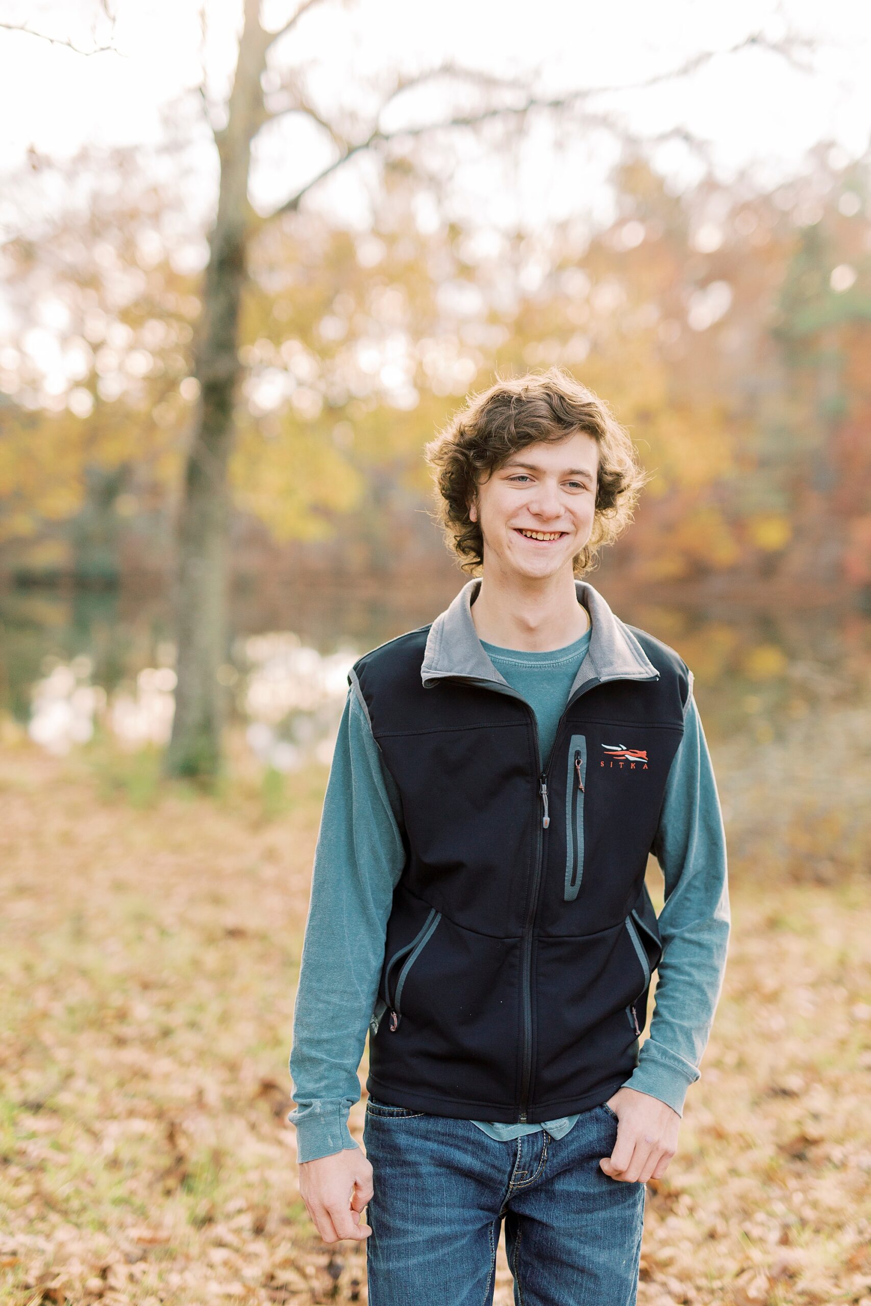 senior boy stands with hands in pockets during portraits in Midland NC