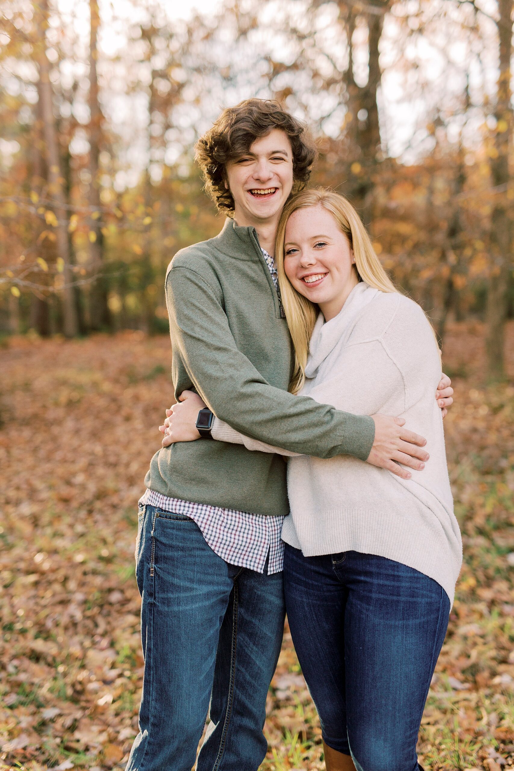 senior hugs sister in white sweater during family photos in NC
