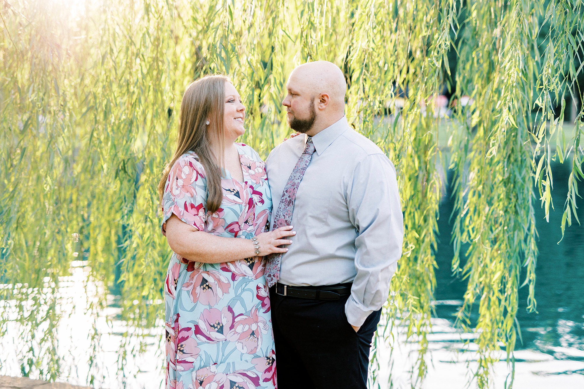 man and woman hug under weeping willow during Freedom Park engagement portraits