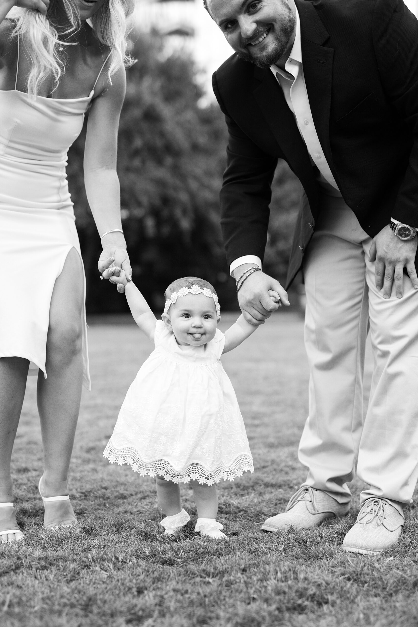 couple holds hands walking with daughter during NC engagement session in park