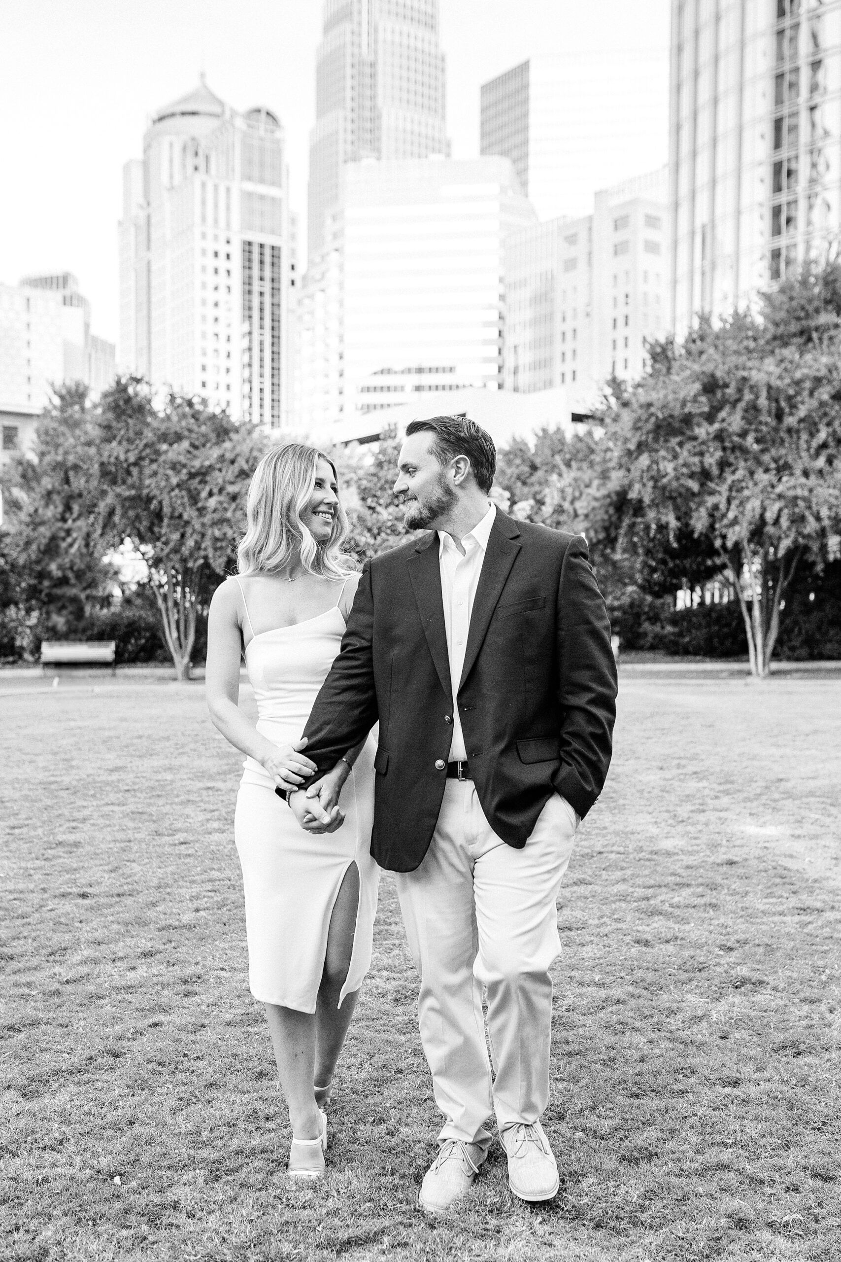 engaged couple holds hands walking through Romare Bearden Park