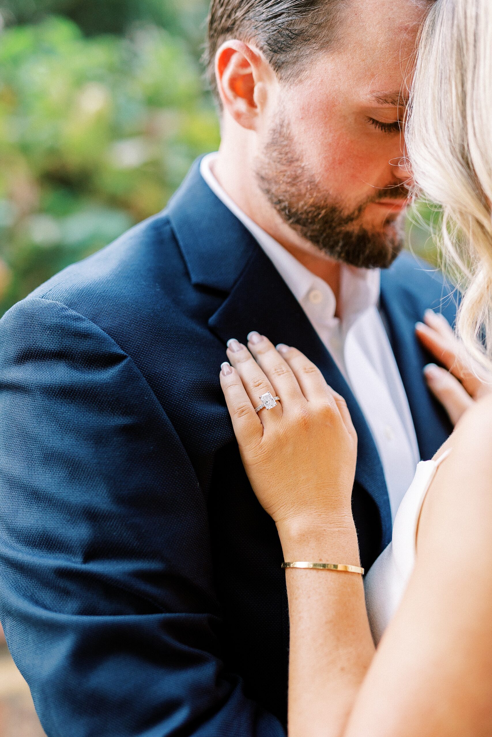 woman puts hand on groom's chest in navy suit 