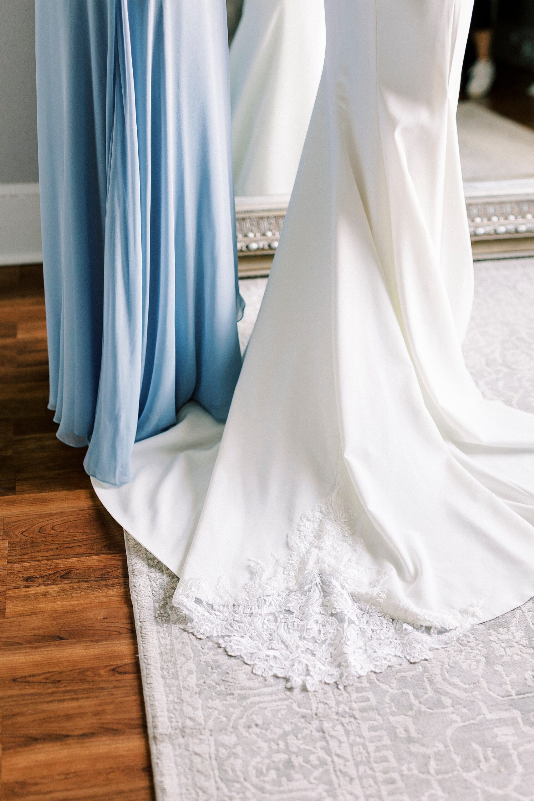 detail photo of wedding dress and blue bridesmaid dress
