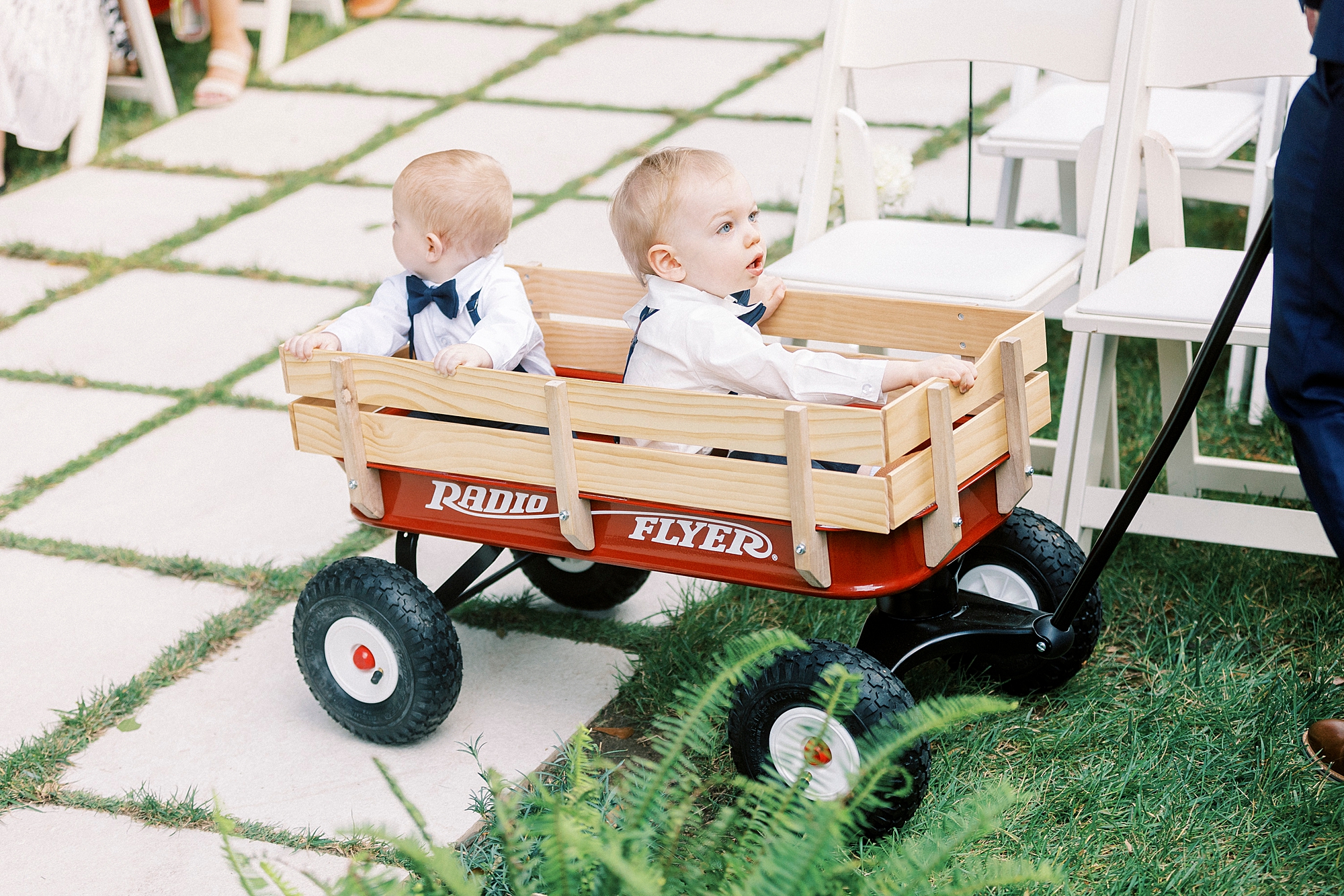 ring bearers ride in red wagon down tiled aisle at Separk Mansion