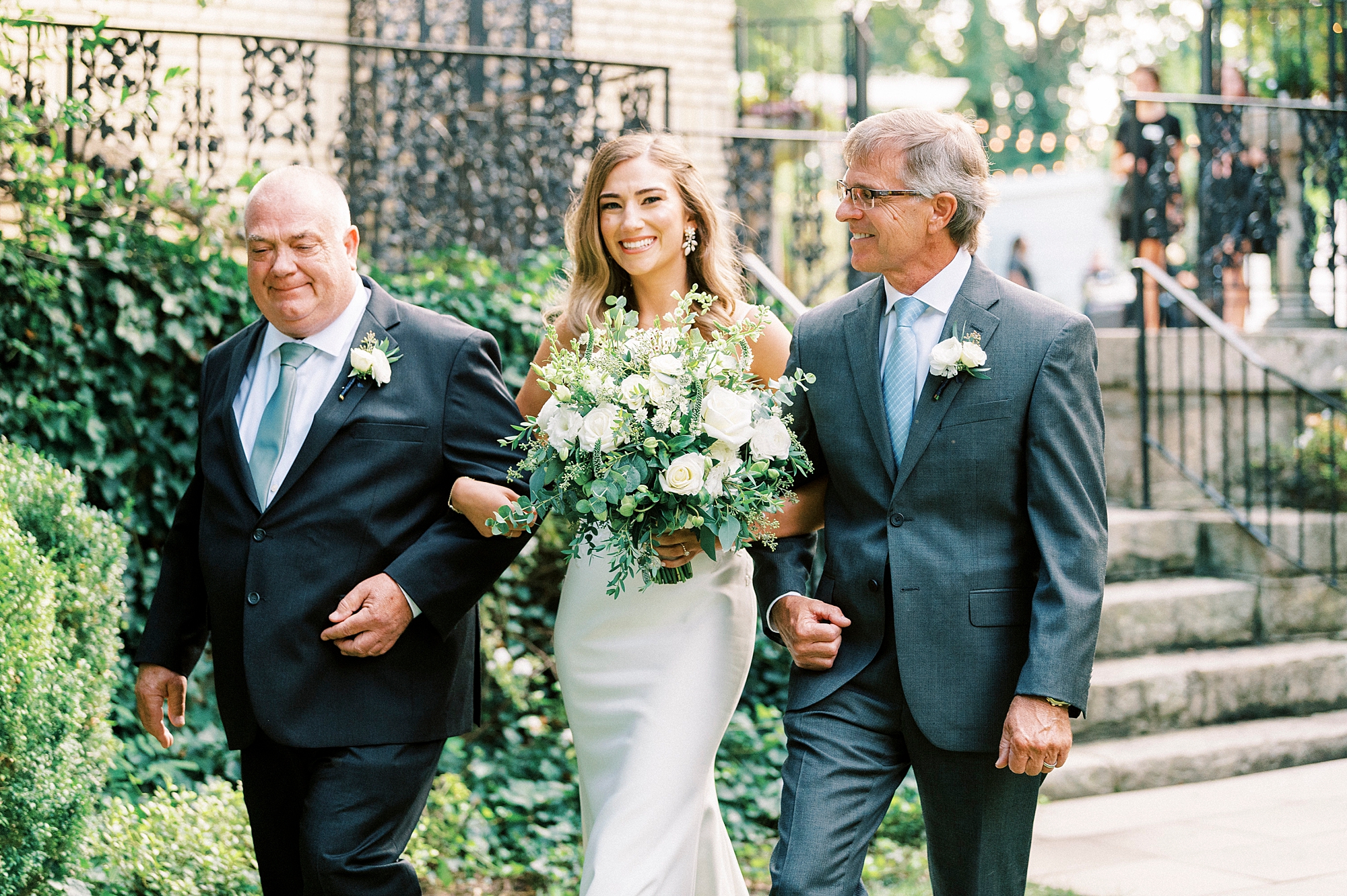 bride walks down aisle with father and step father at Separk Mansion