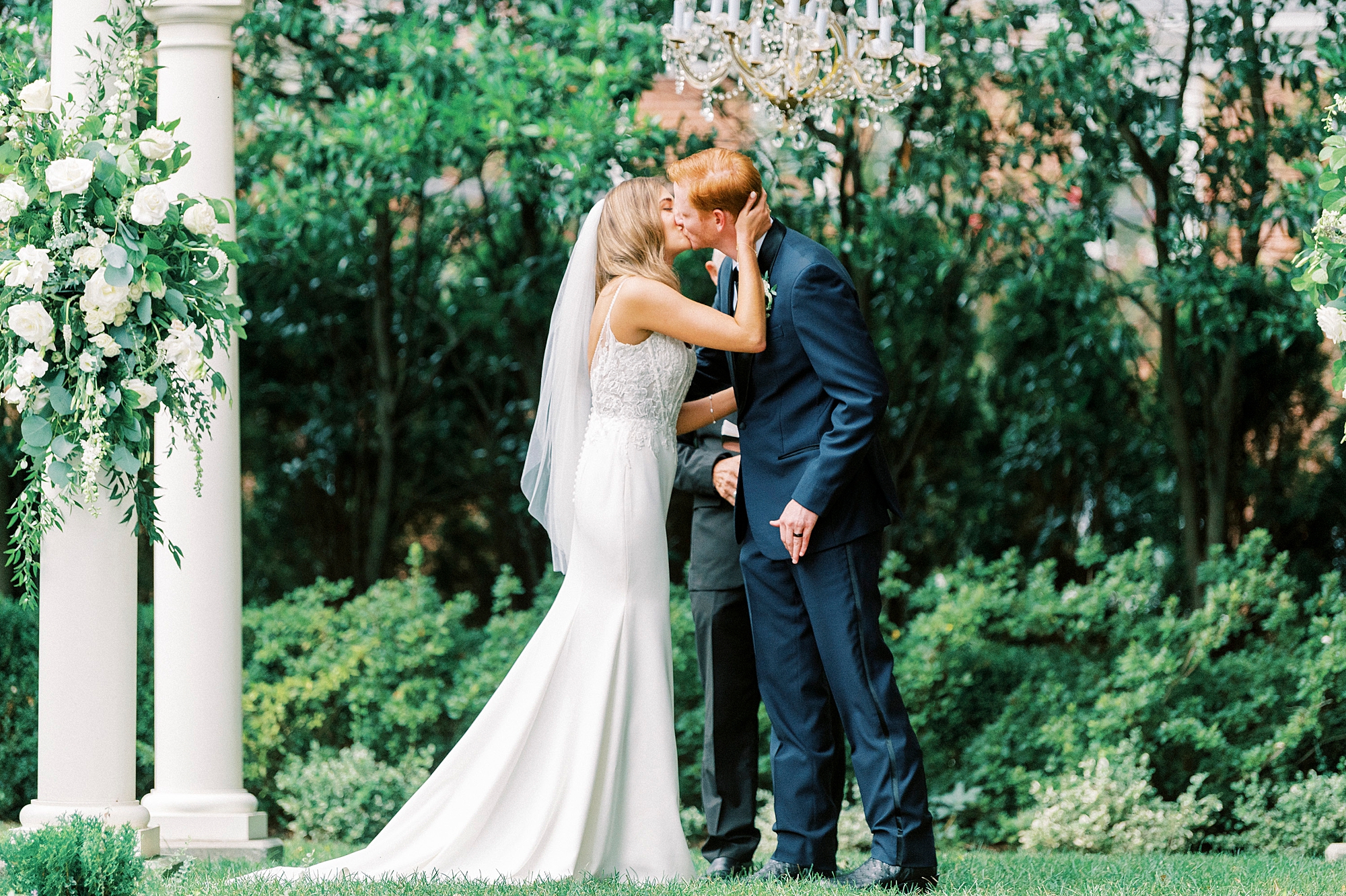 bride and groom kiss under arbor during outdoor wedding ceremony at Separk Mansion