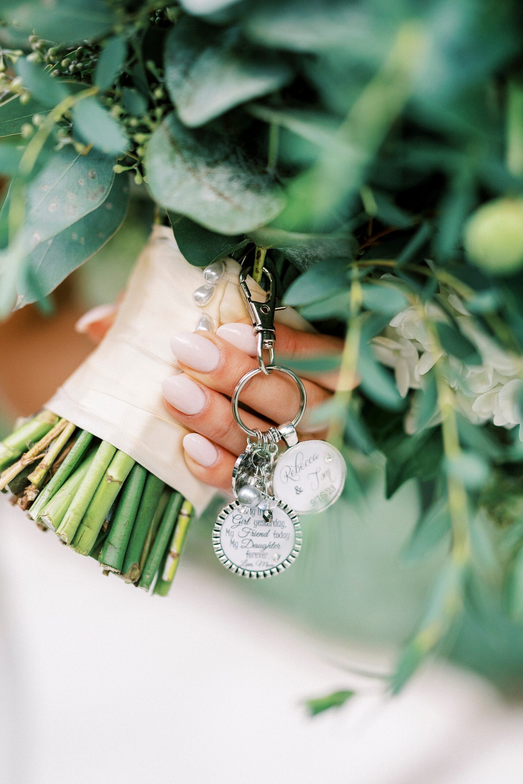 bride holds bouquet of flowers with charms 