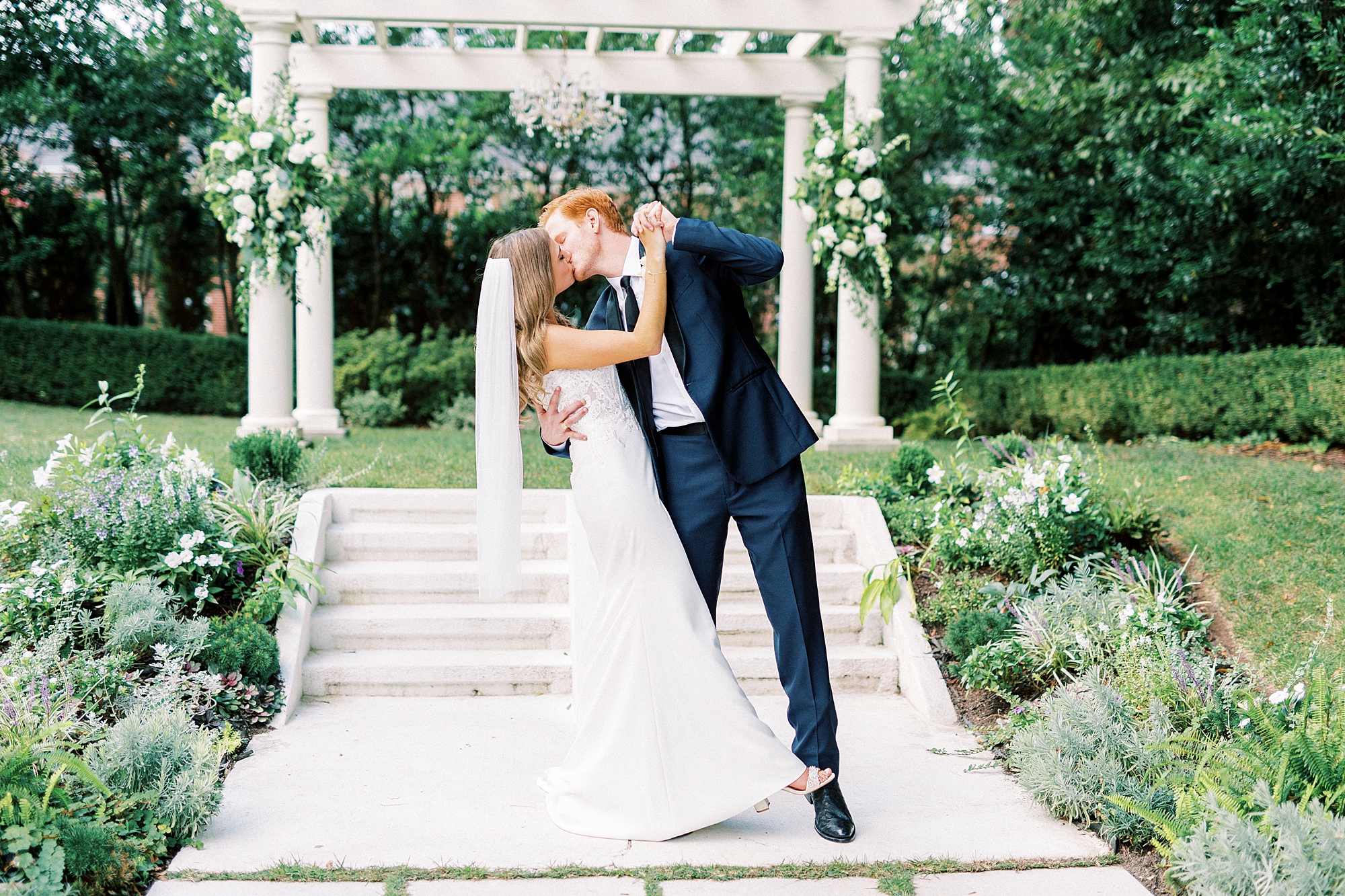 bride and groom kiss in front of Separk Mansion arbor 