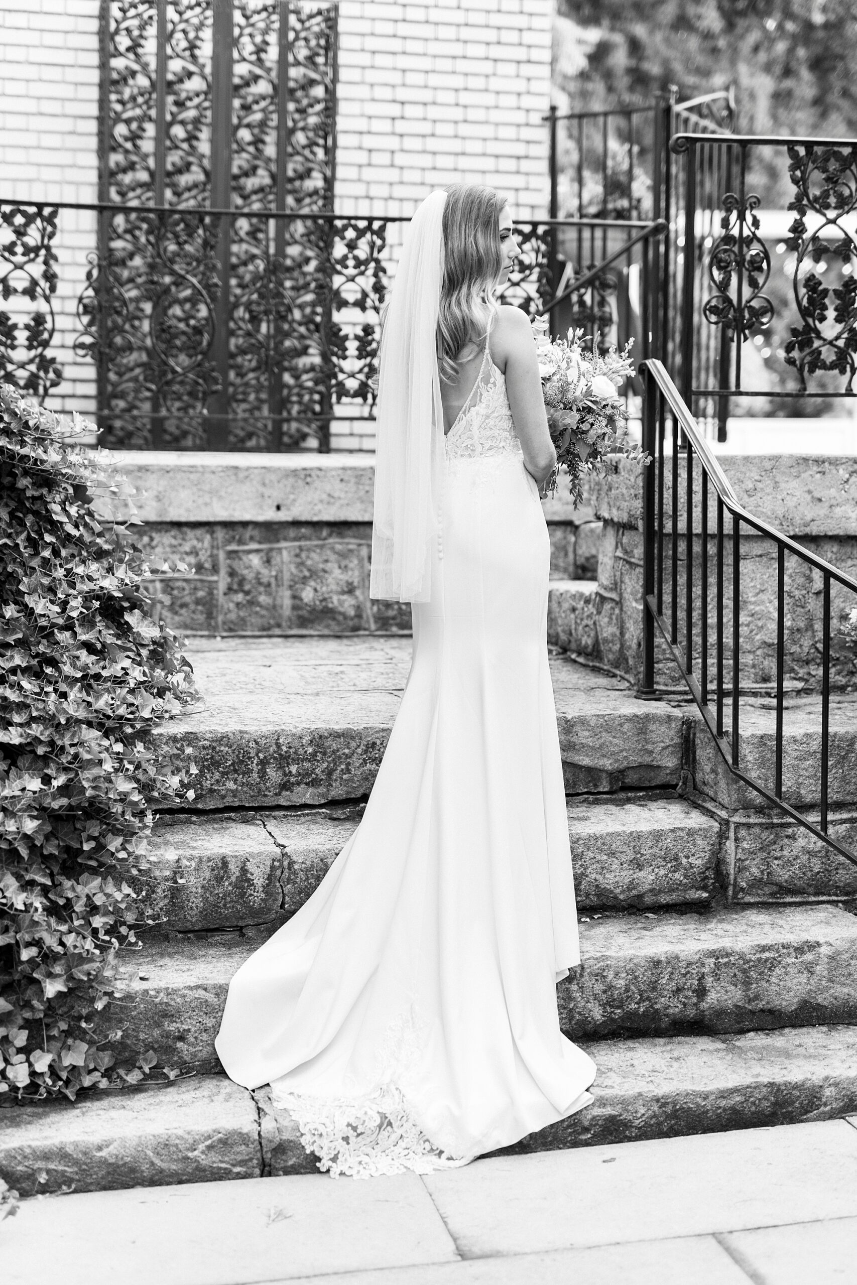 bride stands on steps with veil down her back at Separk Mansion