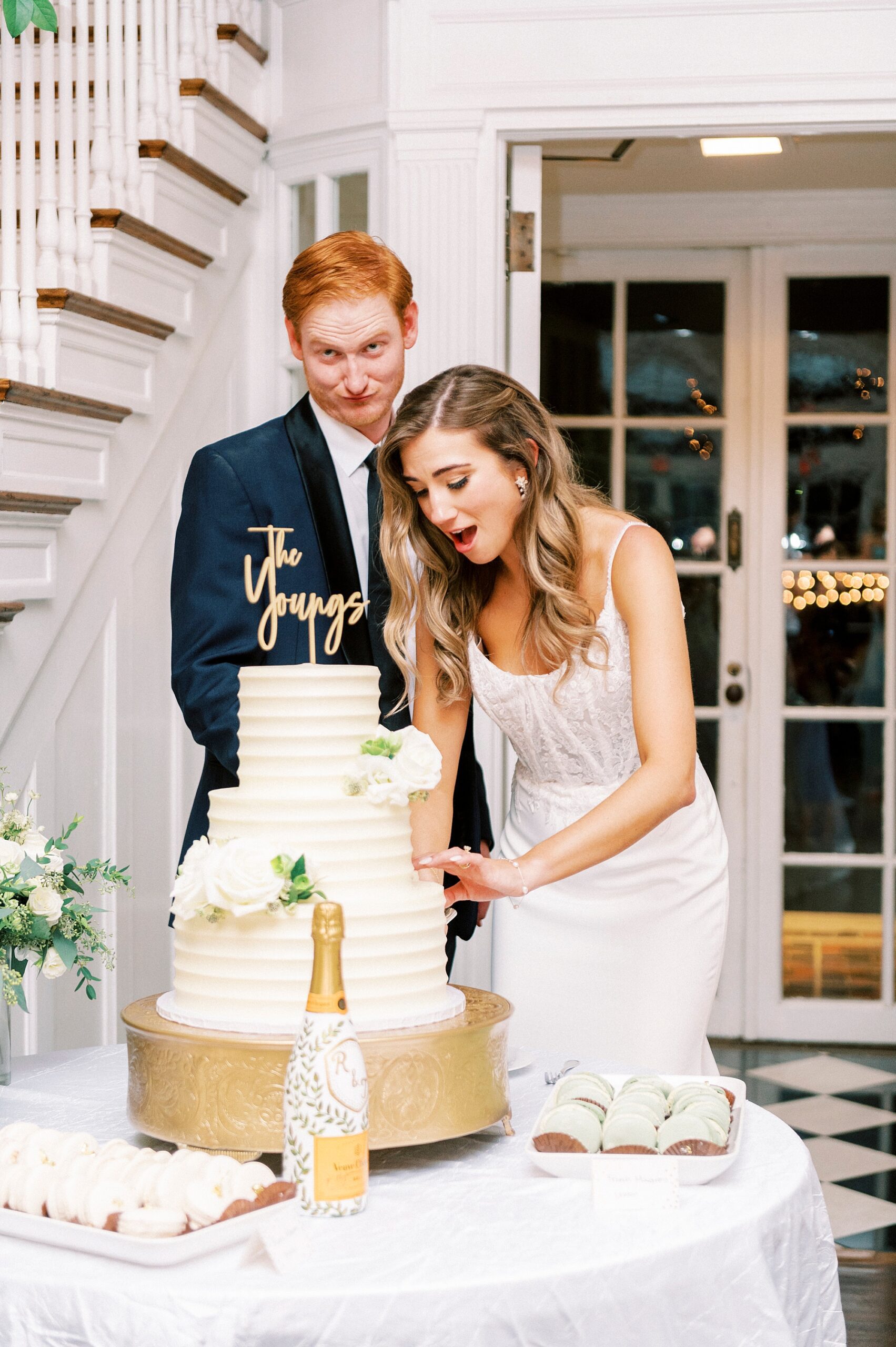 bride cuts wedding cake with groom during NC wedding reception