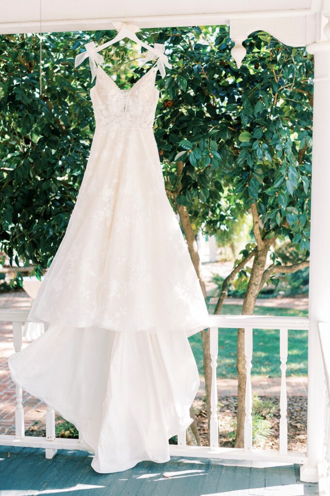 wedding dress hangs on porch at Whitehead Manor