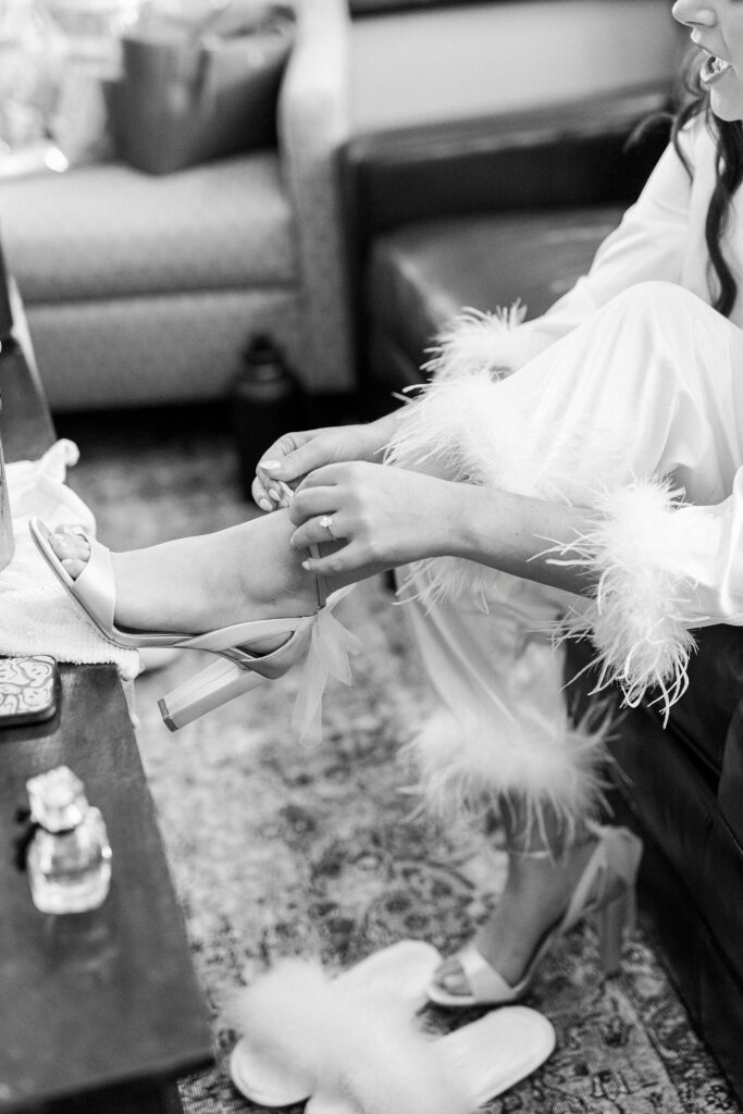 bride puts on heels in pajamas with fuzzy lining