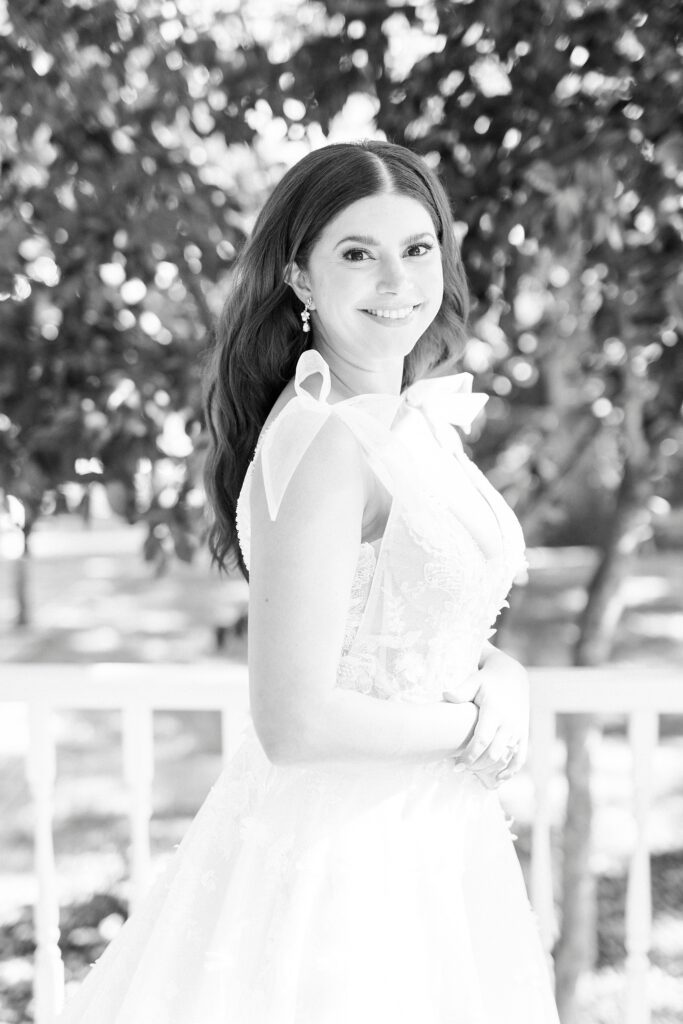 black and white portrait of bride smiling on porch at Whitehead Manor