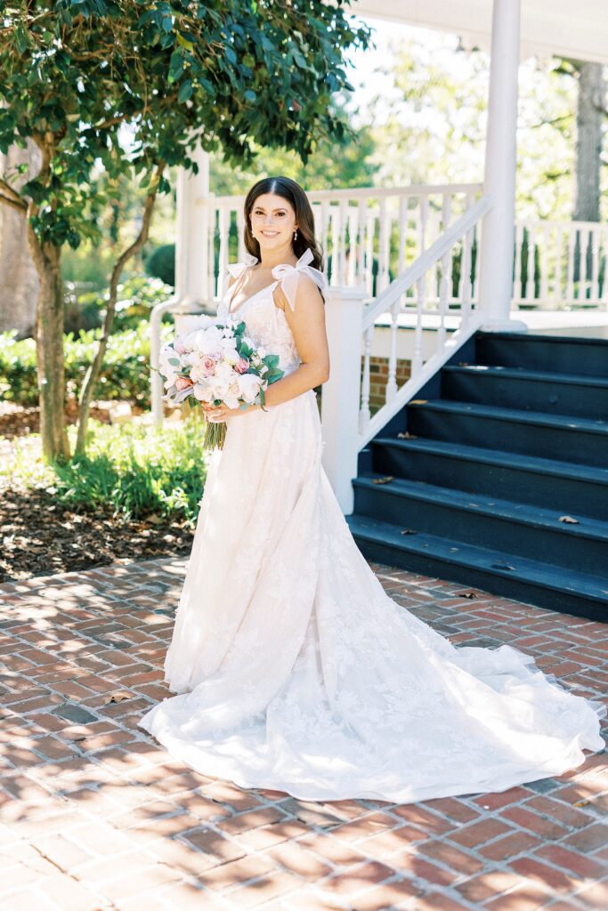 bride holds bouquet of flowers turning in wedding dress