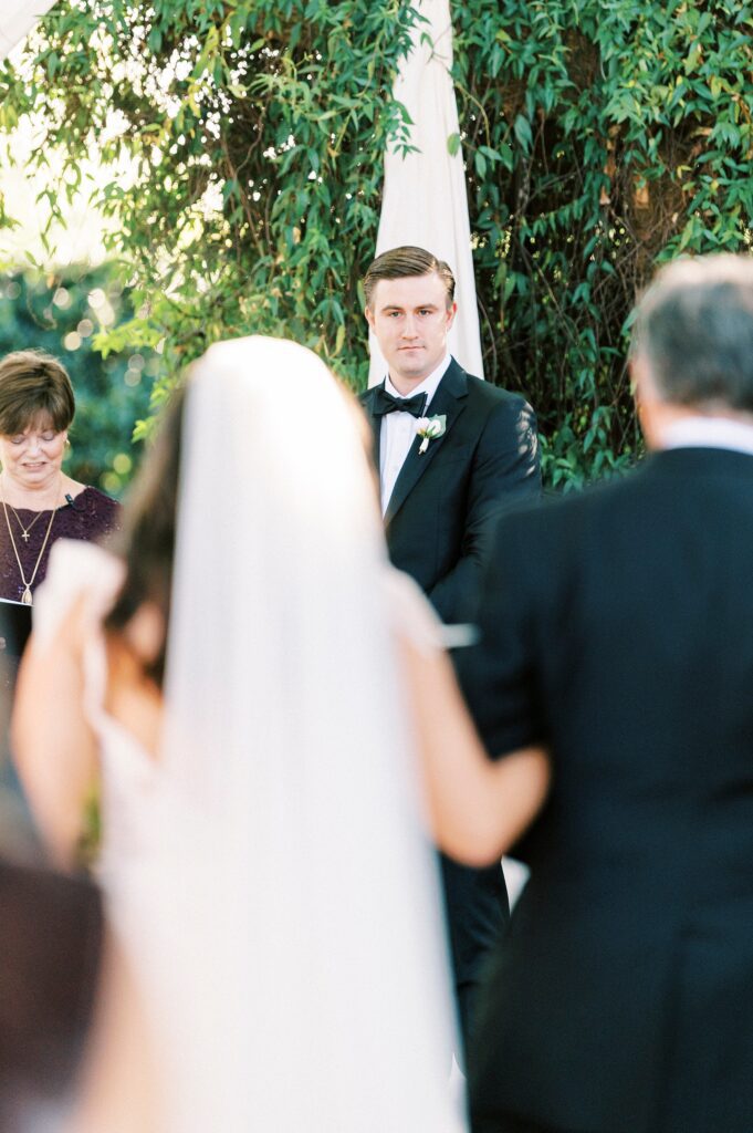 groom watches bride walk down aisle during ceremony in Charlotte NC 