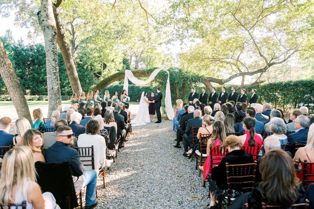 bride and groom exchange vows under oak tree branch at Whitehead Manor