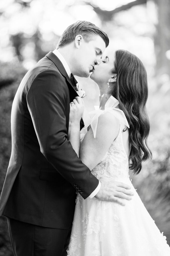 black and white portrait of bride and groom kiss during fall wedding day