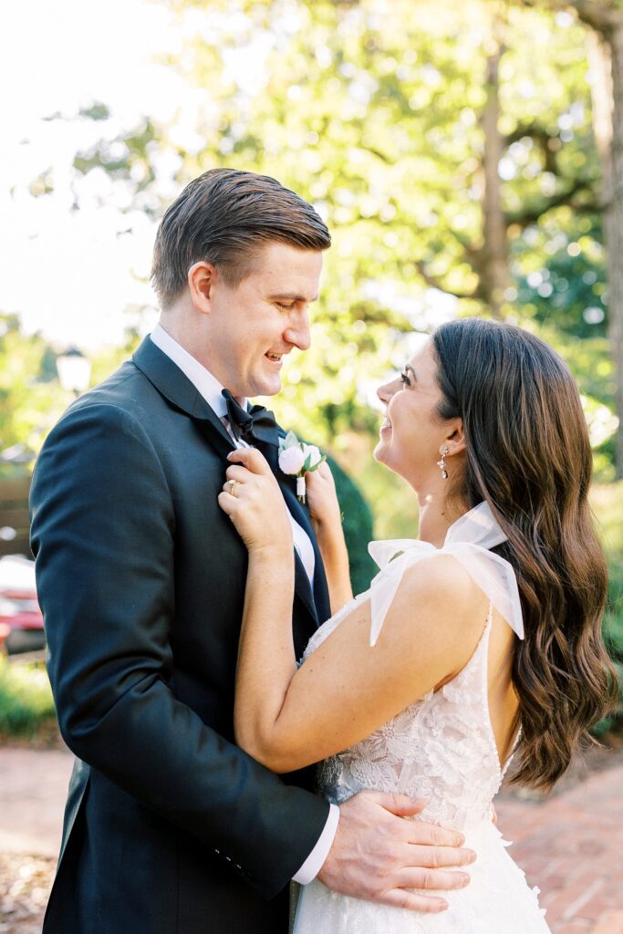 bride looks up at groom holding his lapel during NC wedding portraits 