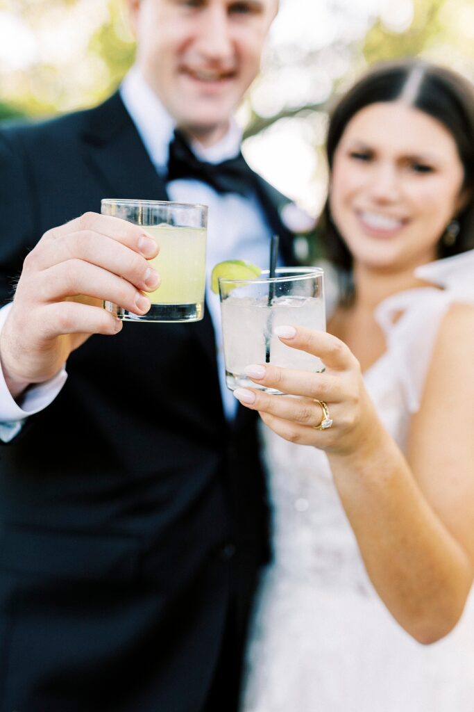 bride and groom hug toasting signature cocktails 