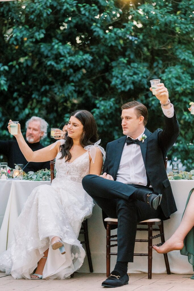 bride and groom lift cocktails during toasts at Whitehead Manor