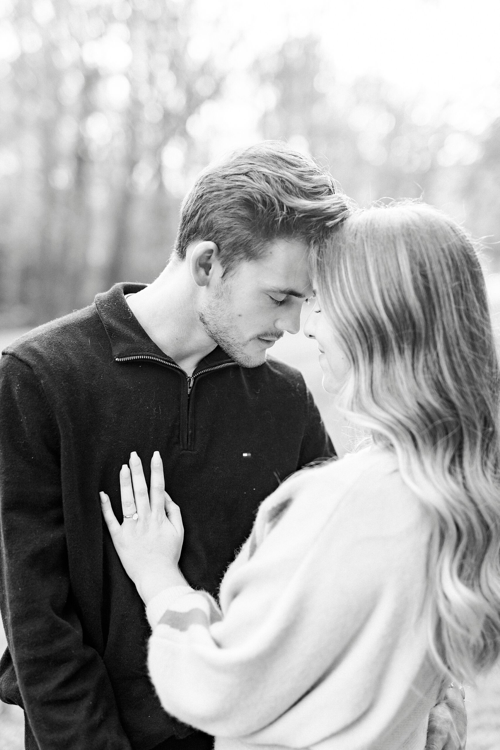 engaged couple leans heads together in park during fall engagement session
