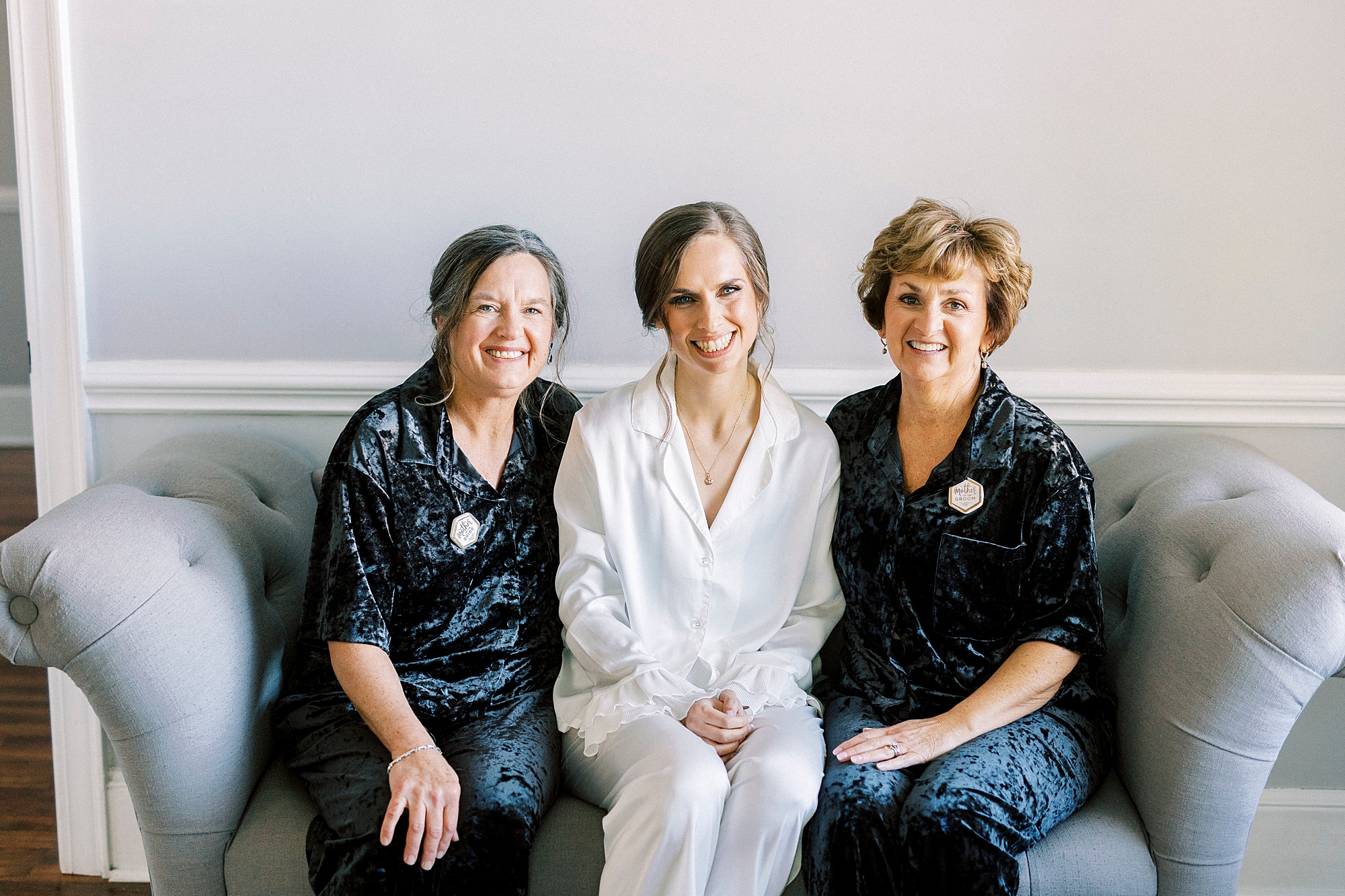 bride sits on couch with mother and mother in law during prep at Separk Mansion