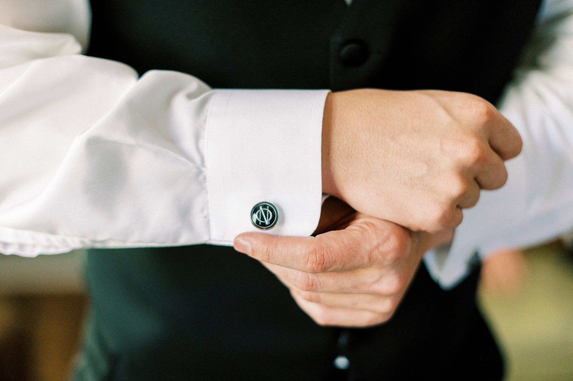 groom adjusts custom cufflinks during prep for NC wedding day