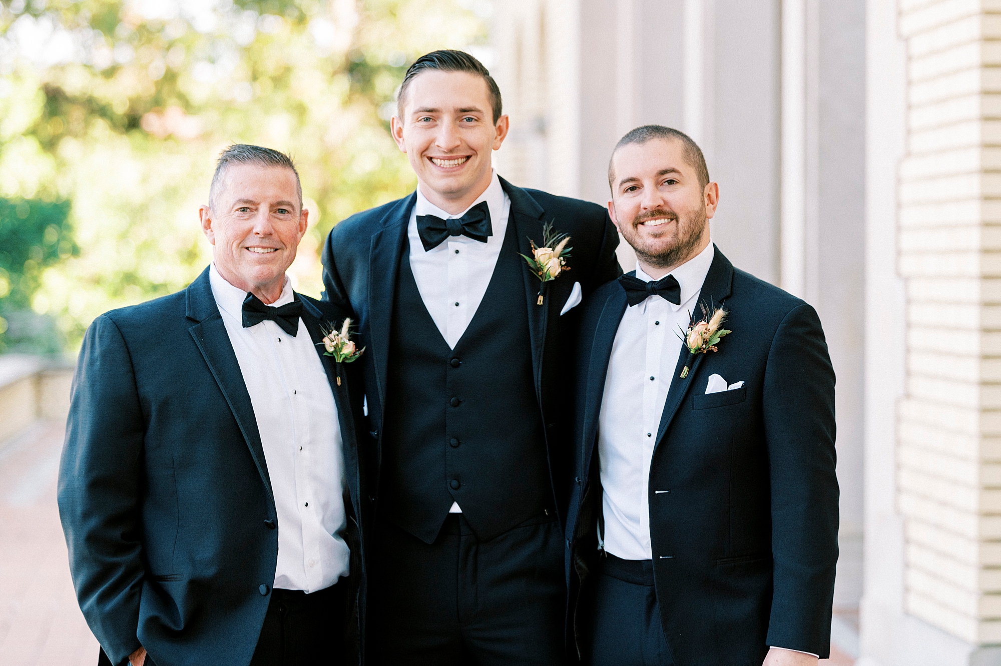 groom stands with father and brother during fall wedding at Separk Mansion