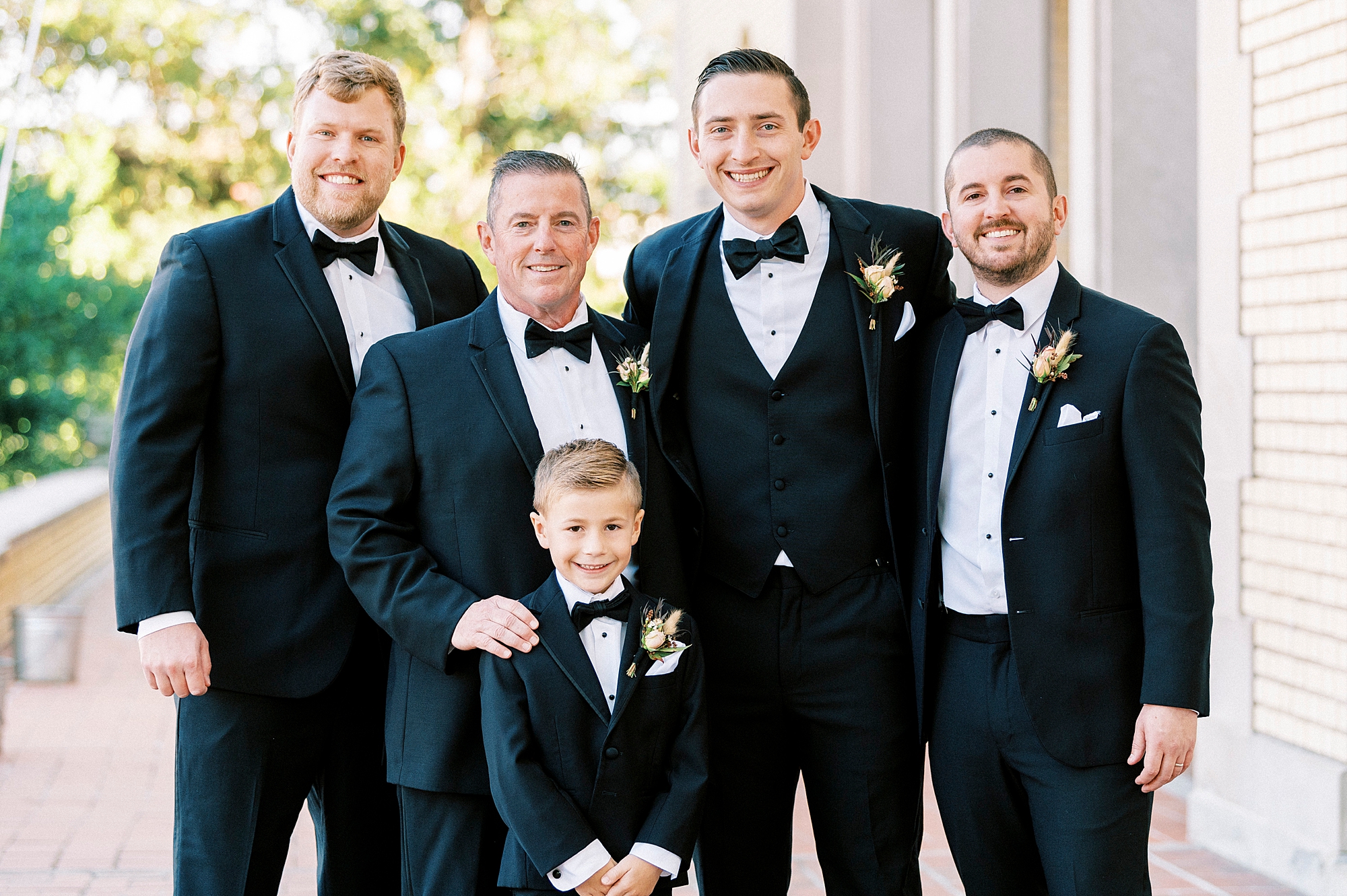 groomsmen hug groom in black suit during fall wedding at Separk Mansion
