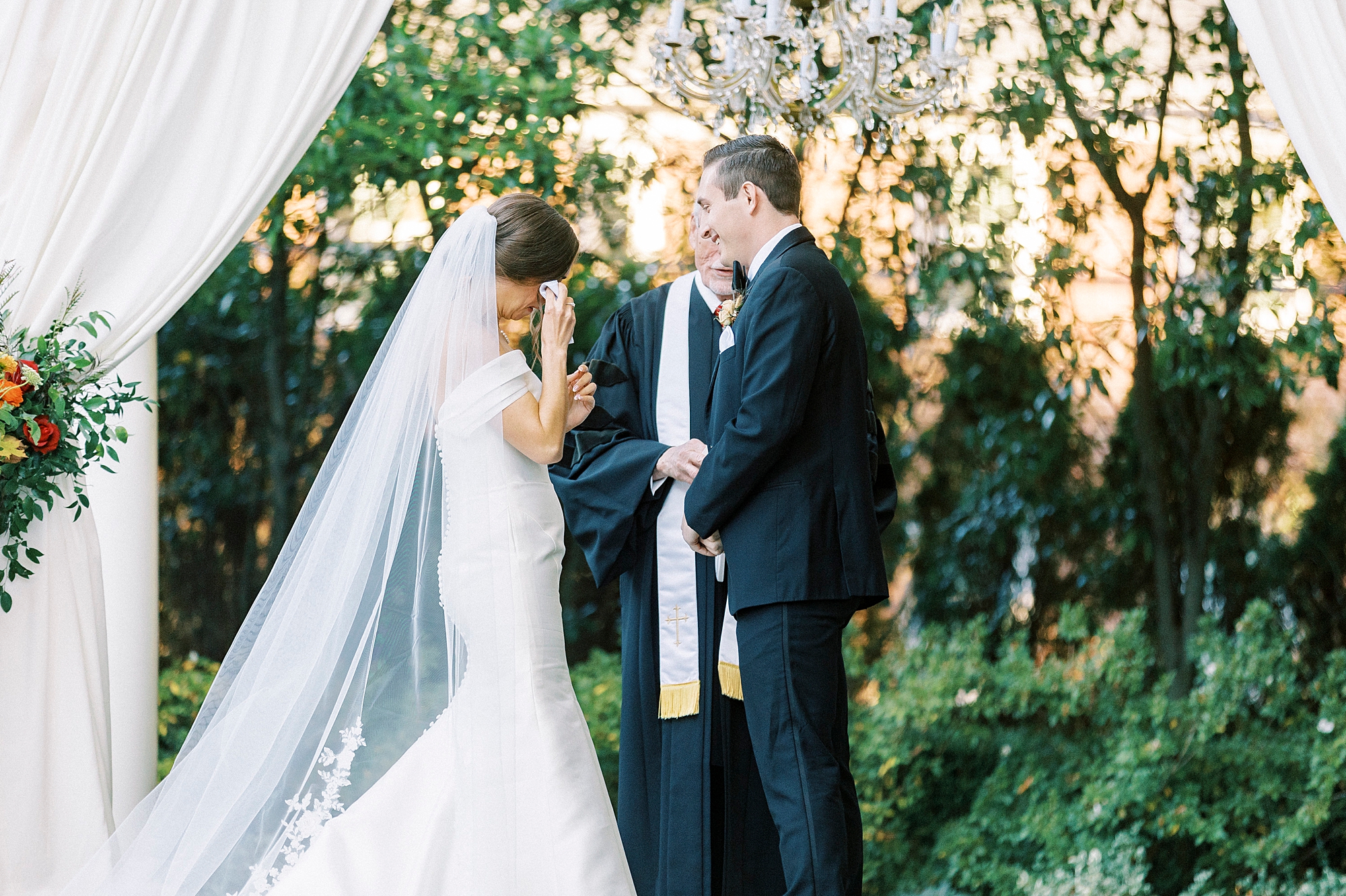 bride wipes away tears during outdoor ceremony at Separk Mansion