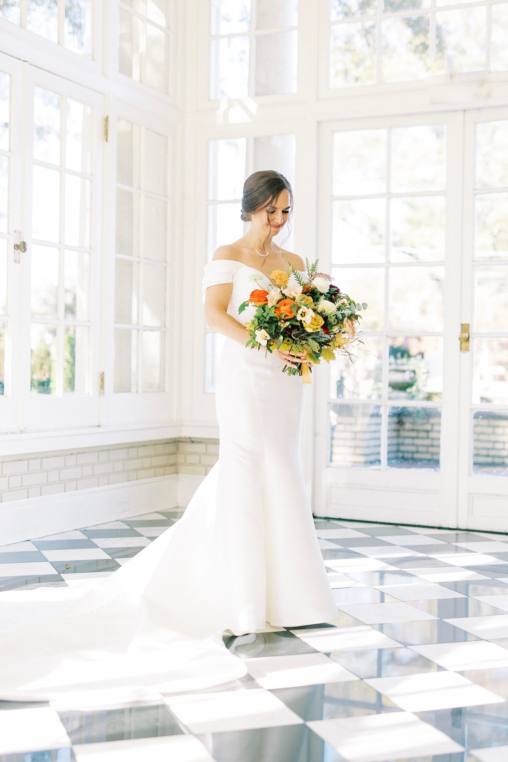  bride holds bouquet of yellow, white, and orange flowers at Separk Mansion
