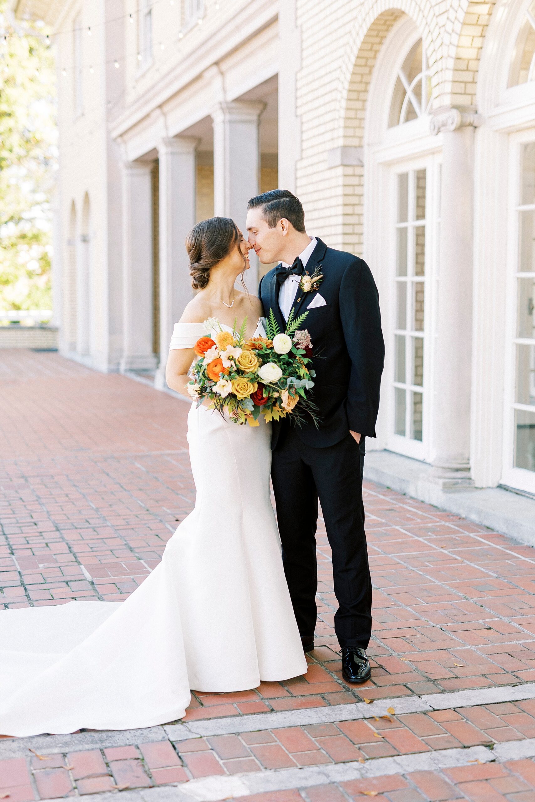 bride and groom lean for a kiss on patio at Separk Mansion