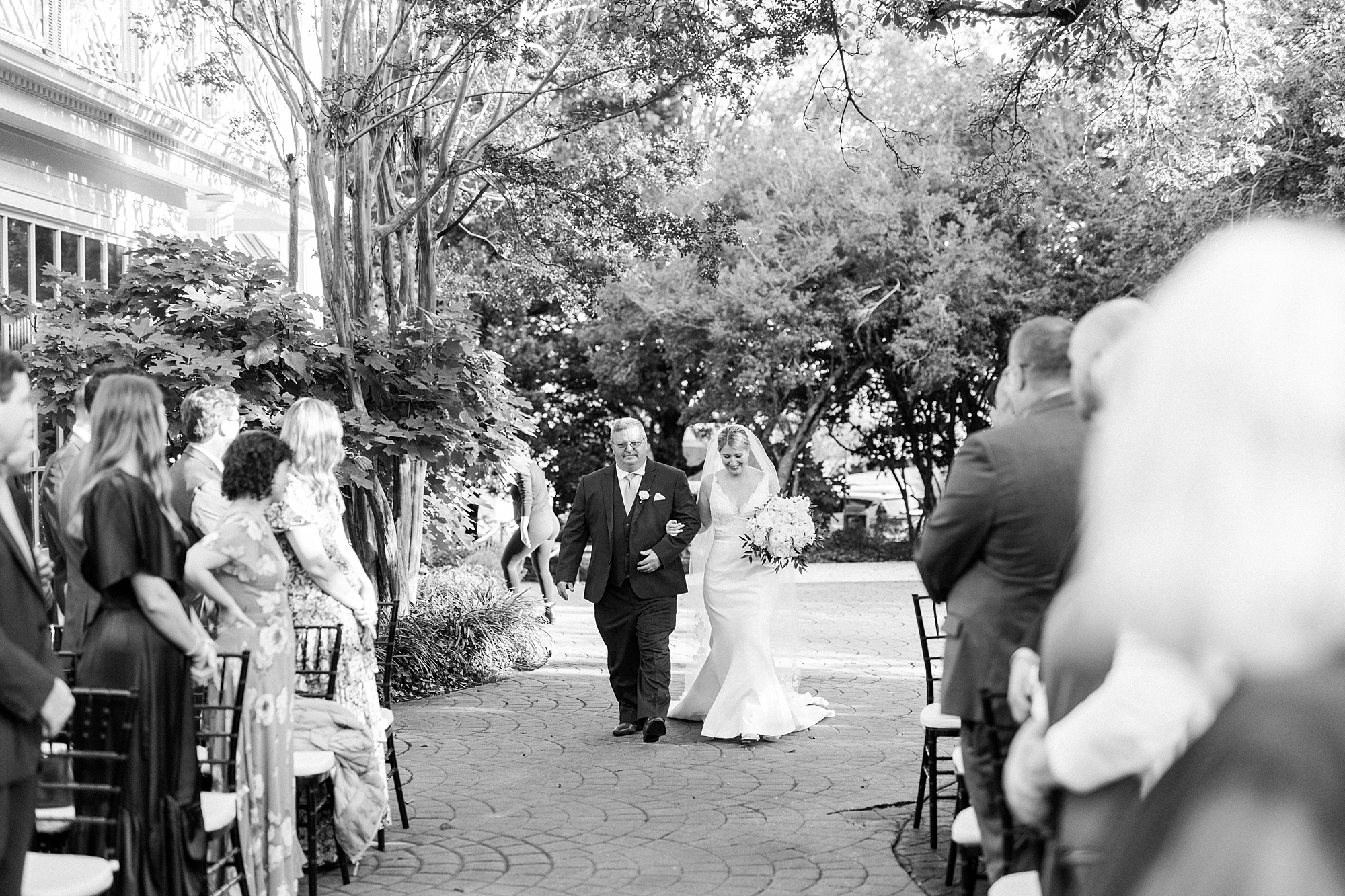 bride walks down aisle at the Morehead Inn with father 