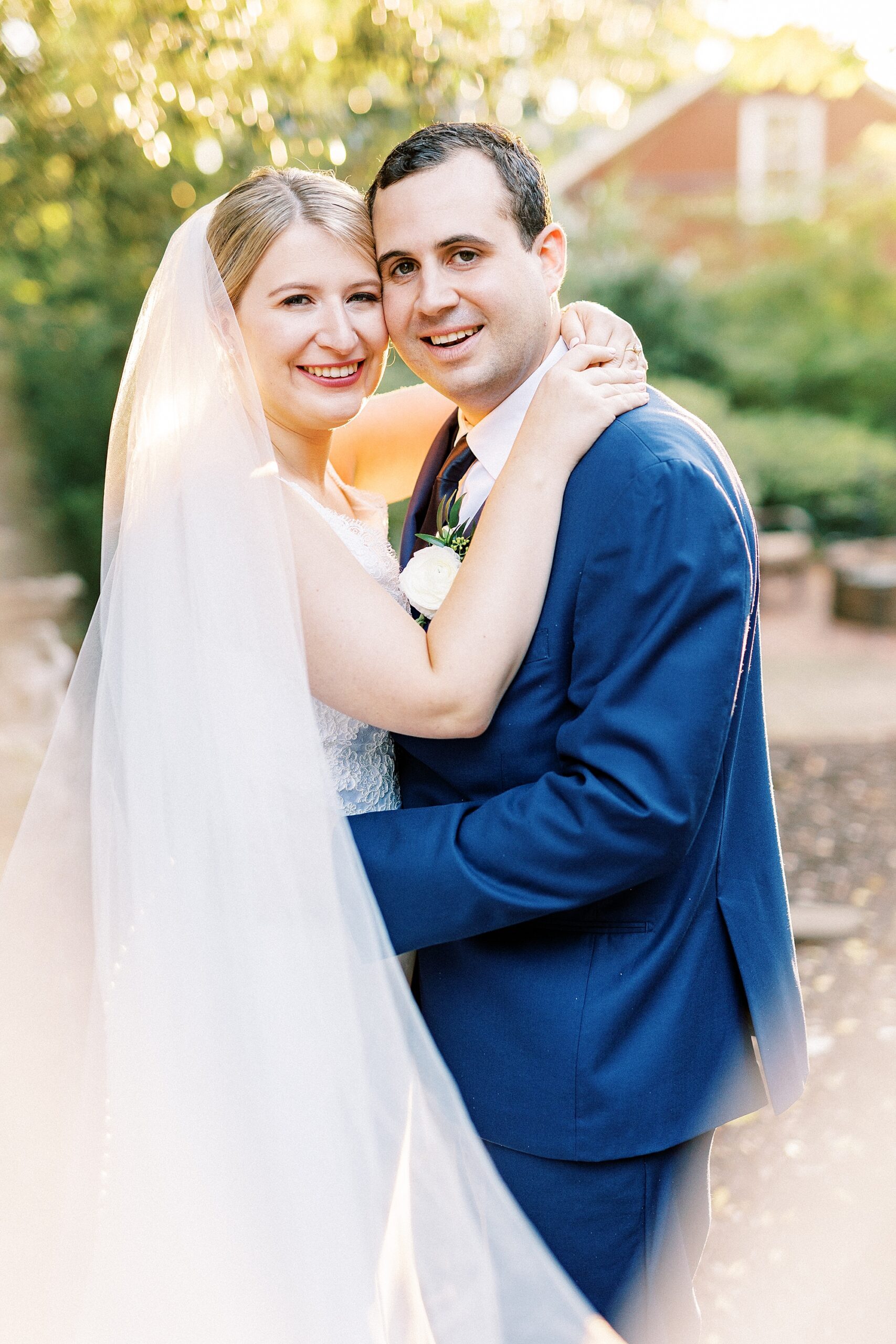 bride and groom hug leaning together during fall wedding day at the Morehead Inn