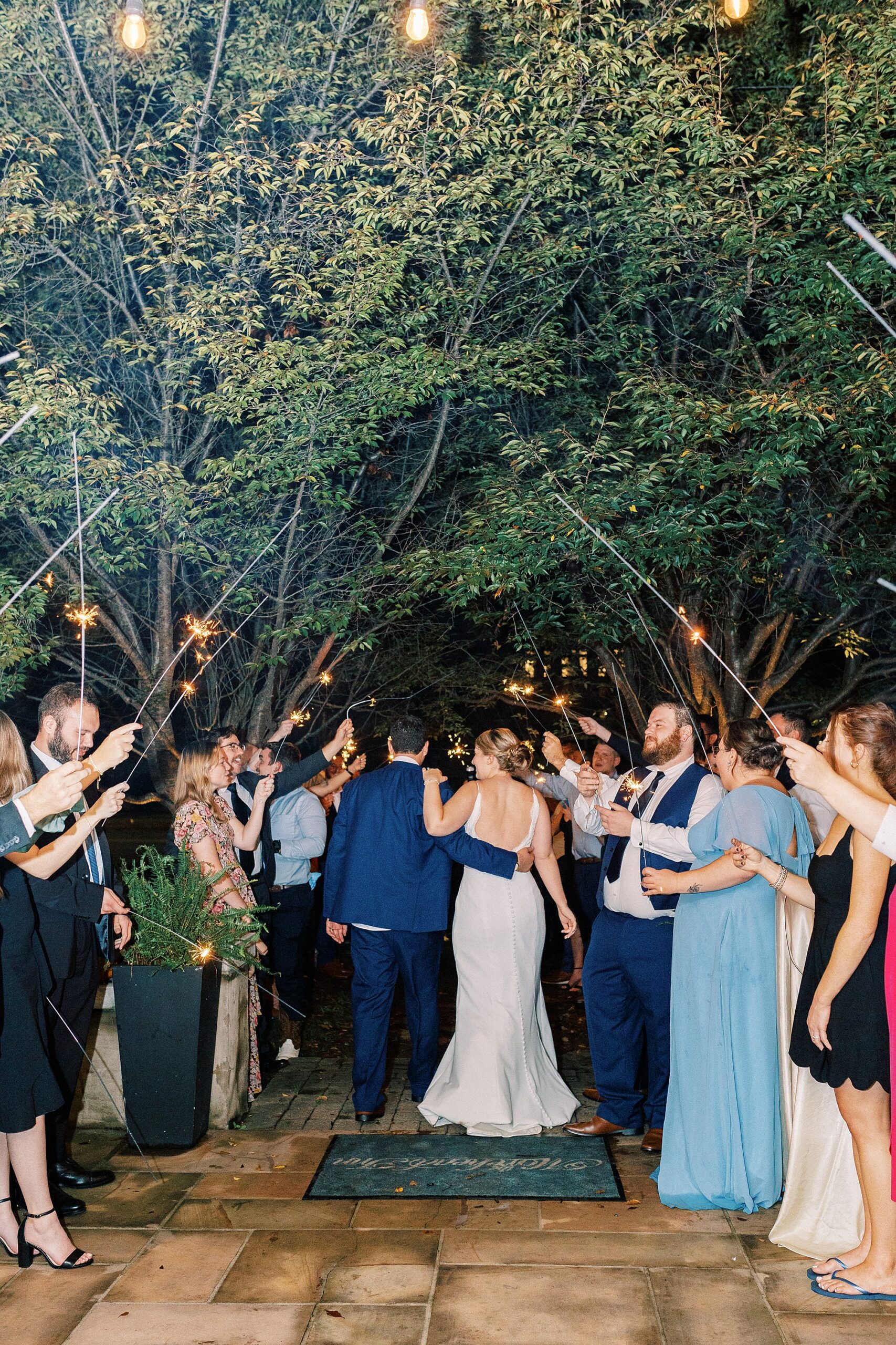 newlyweds hug under sparklers during exit from NC wedding reception 