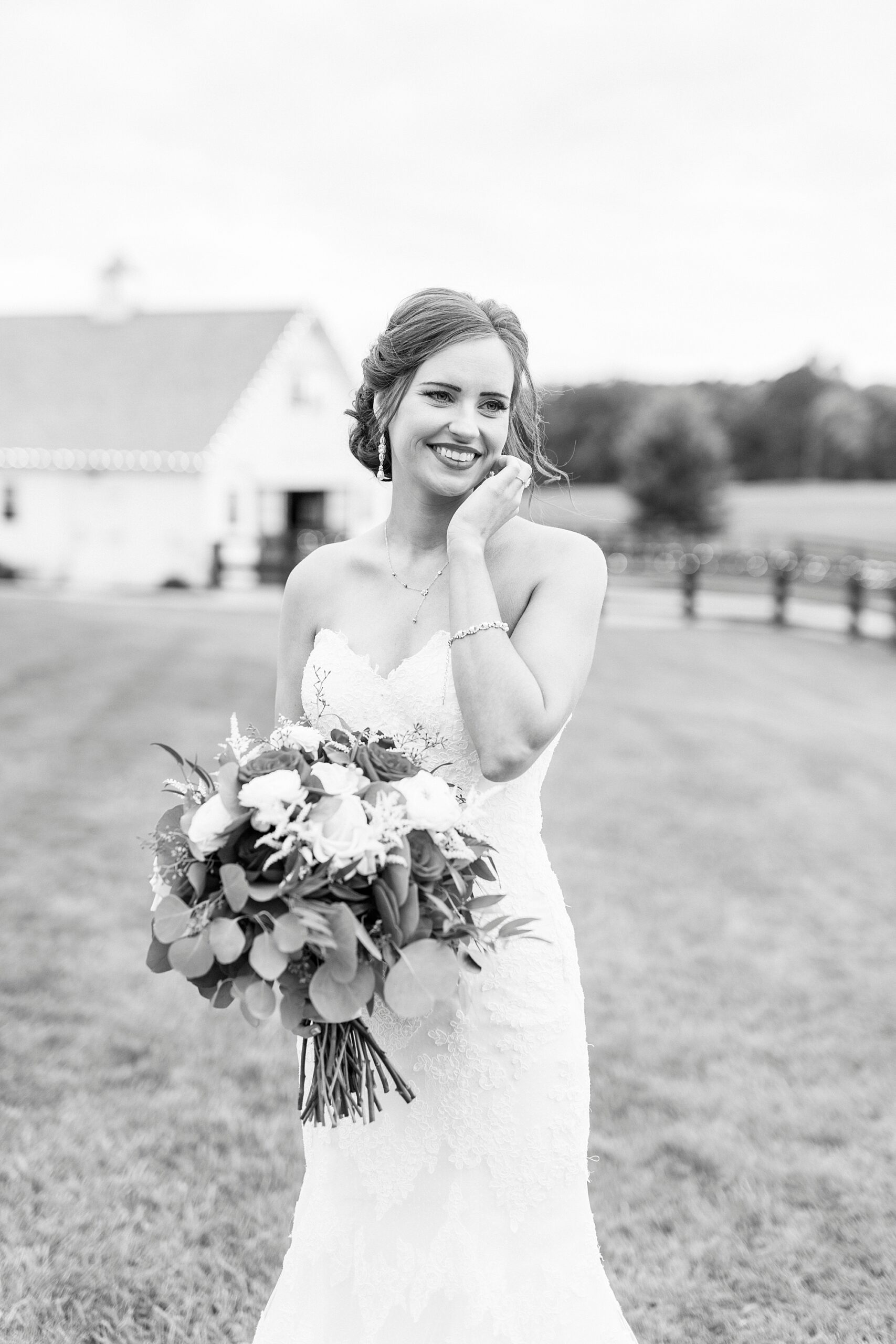 bride stands with hand under her chin at Chickadee Hill Farms