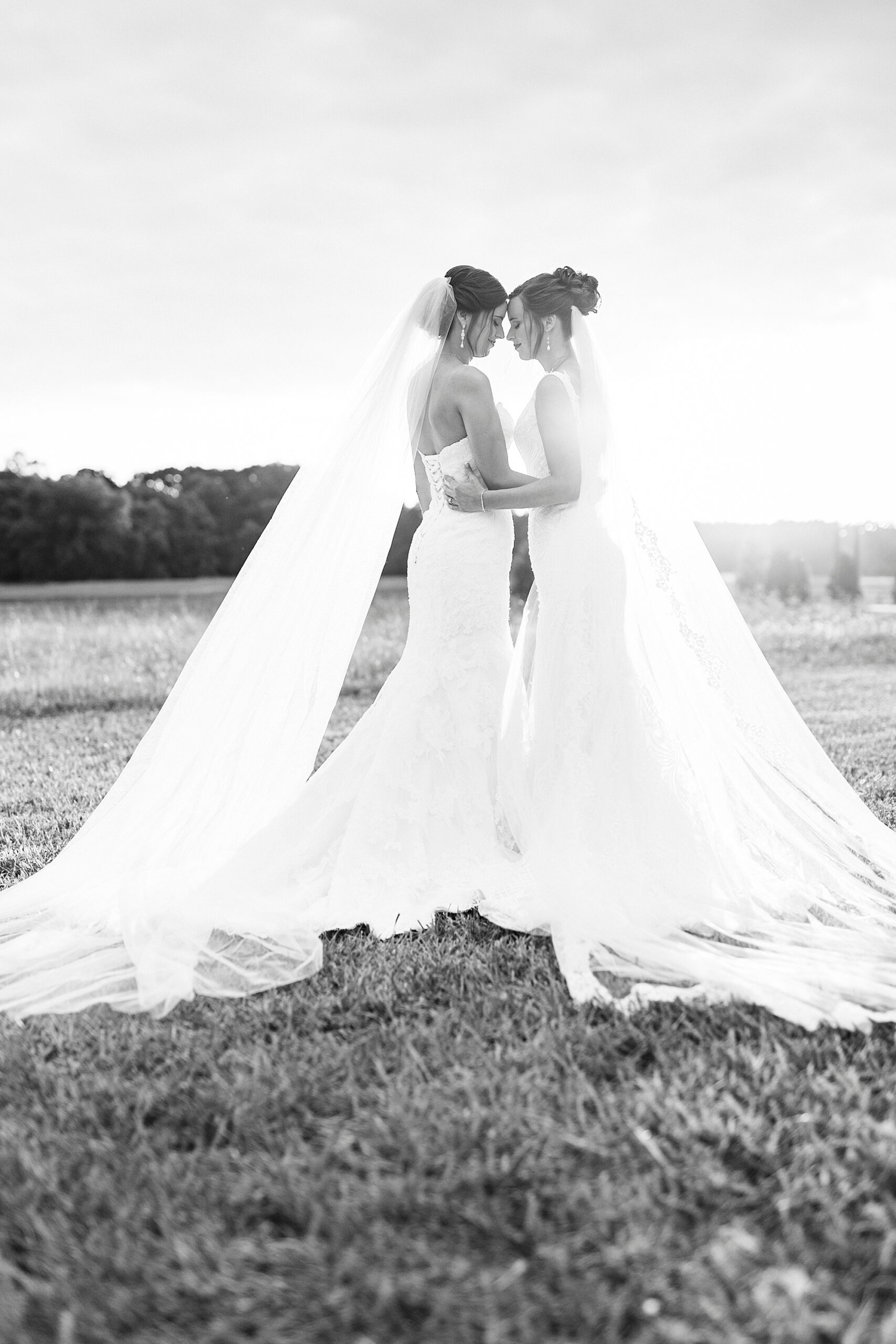 bride and sister stand together in wedding gowns in North Carolina 