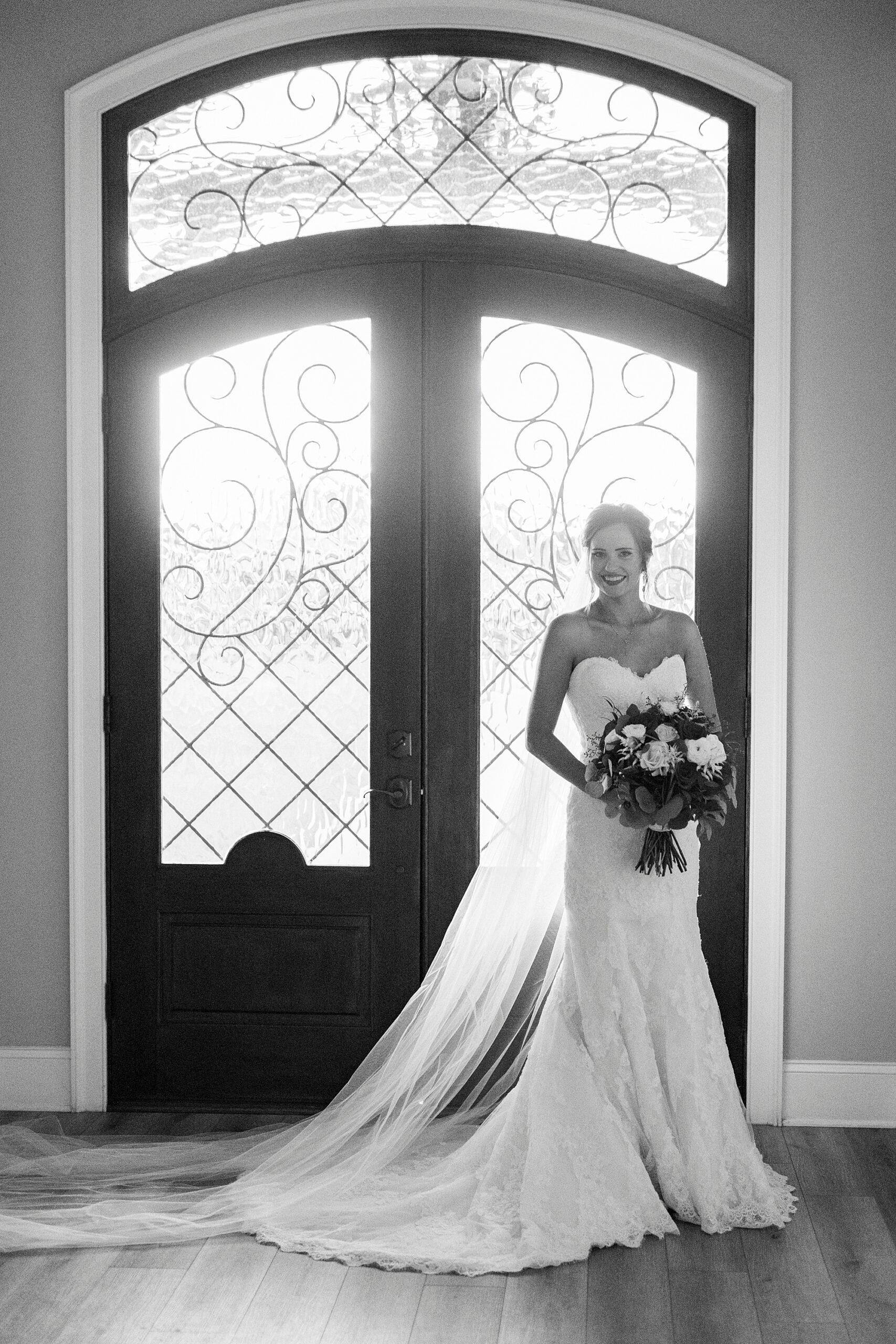 bride poses in front of chapel door at Chickadee Hill Farms