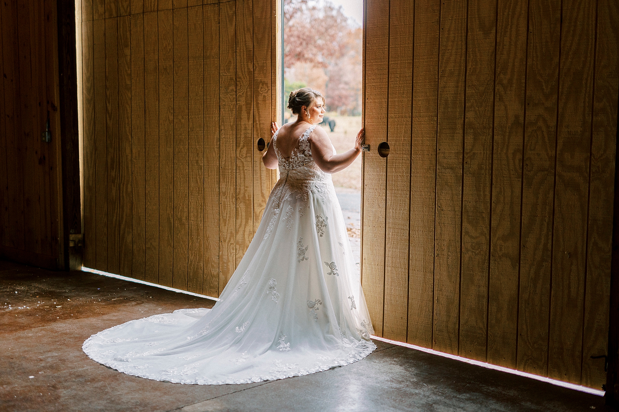 bride opens barn doors at the Farm at Brusharbor in wedding dress