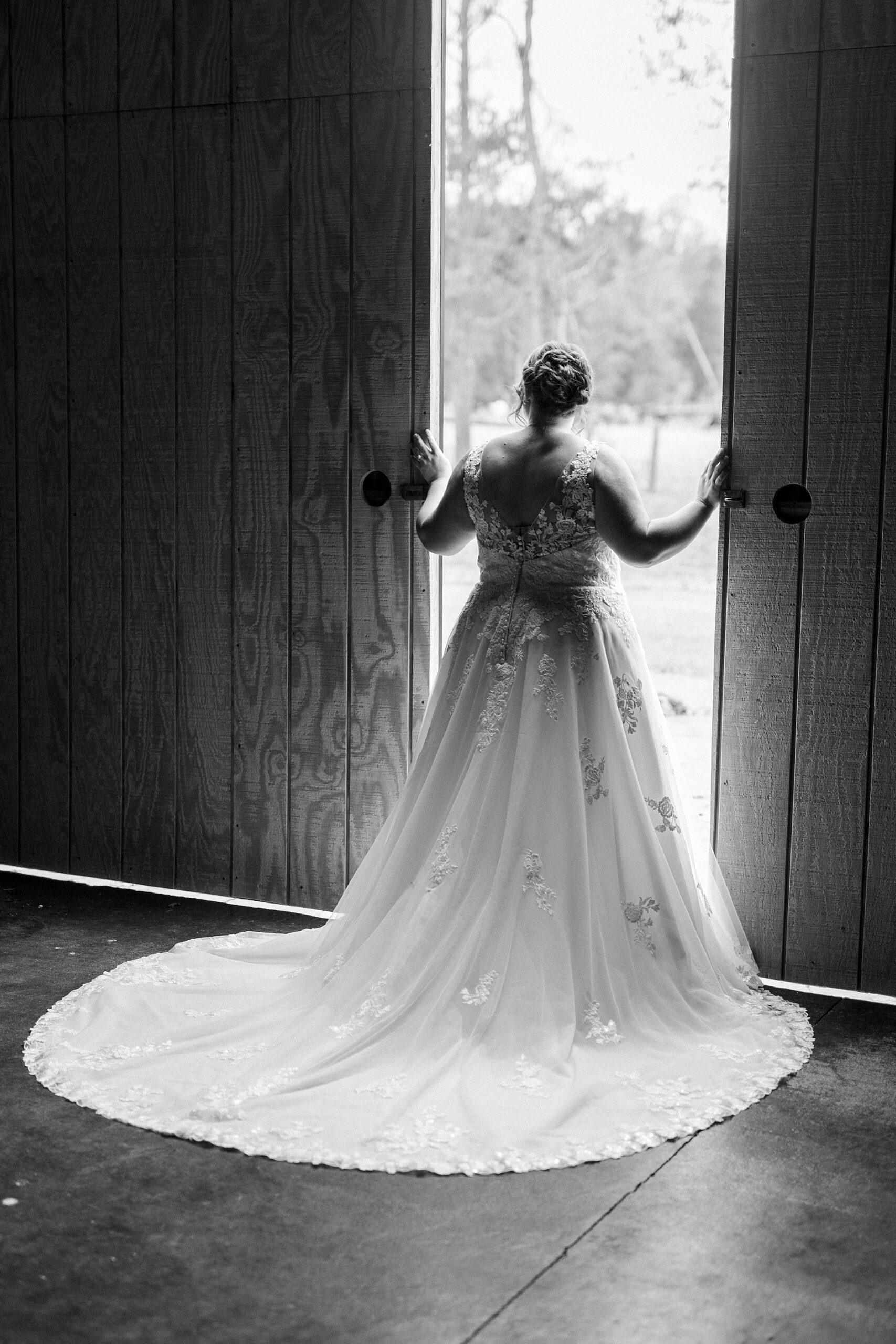 bride looks out barn doors during bridal portraits at the Farm at Brusharbor